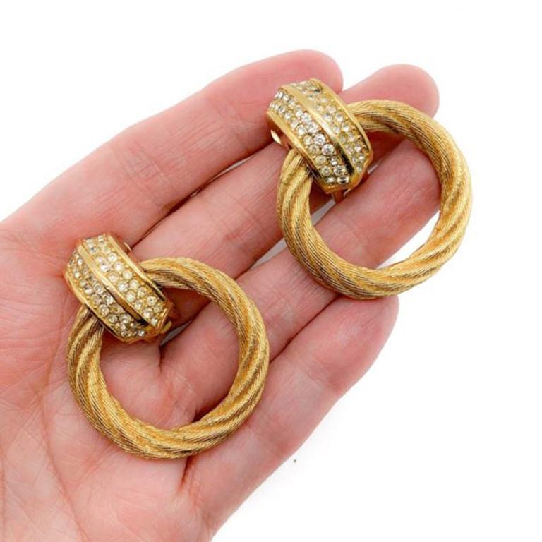 Nothing screams style like the gold hoop earring. Stunning Vintage Dior Hoop Earrings have it all. Featuring gold plated metal, Swarovski Crystal embellishment and clip fasteners. Signed and in very good vintage condition. Approx. 4.5cm long.