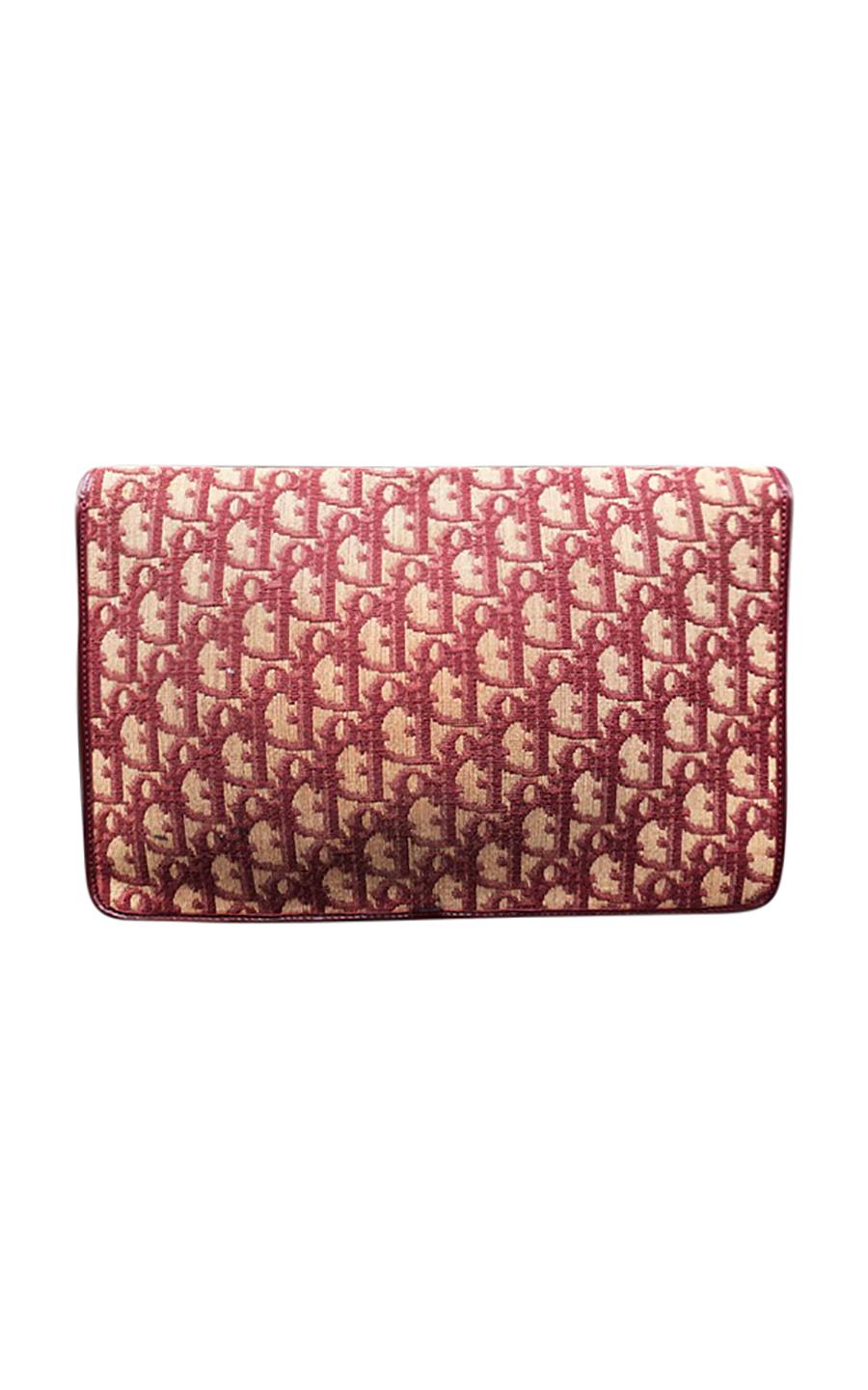 Vintage Christian Dior Trotter wristlet clutch bag, in good pre-loved condition. Dating to the 1970's, this unique bag comes in the Trotter monogrammed canvas print, adorned with burgundy leather accents. The interior is lined with burgundy leather,