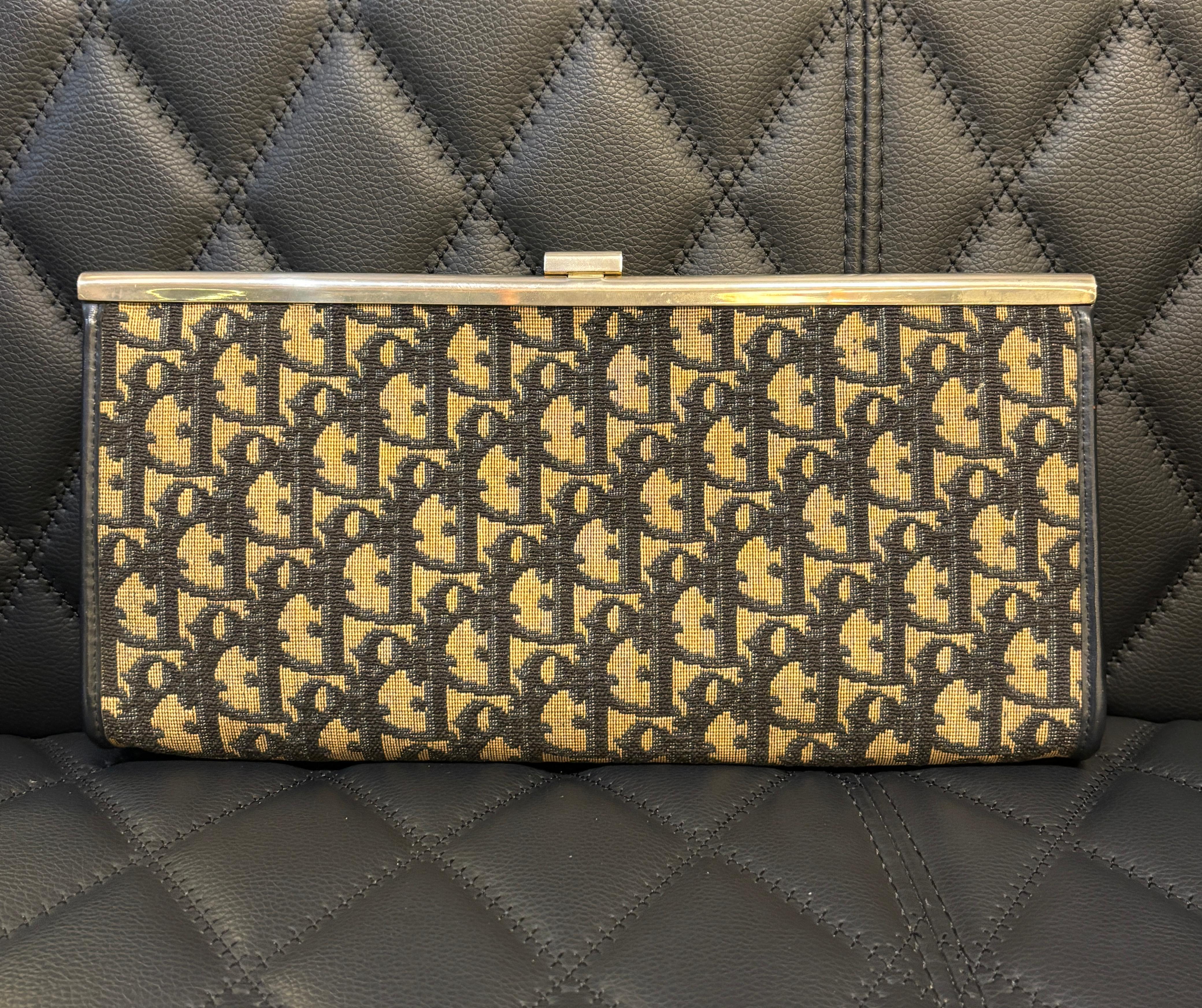 Pochette classique vintage dior oblique avec logo en métal cd. Légers signes d'usure et de stockage. Légère décoloration de la quincaillerie métallique. Jaunissement de la toile. Légers plis sur la doublure en cuir. Ce modèle ne comporte pas