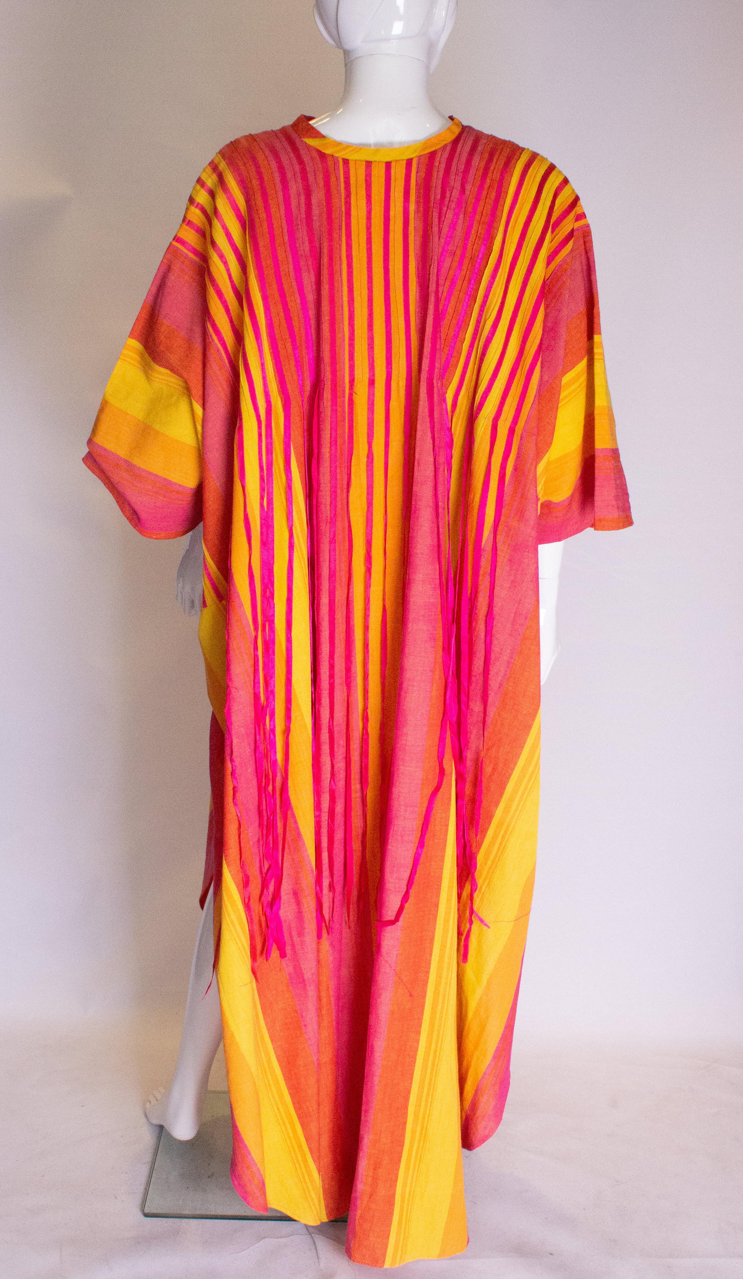 A great colourful, cotton kaftan by Diseno Josefa. The kaftan is in a wonderful cotton with verticla stripes in pink and yellow with ribbon detail, with slits on either side. It will fit a bust up to 46''.