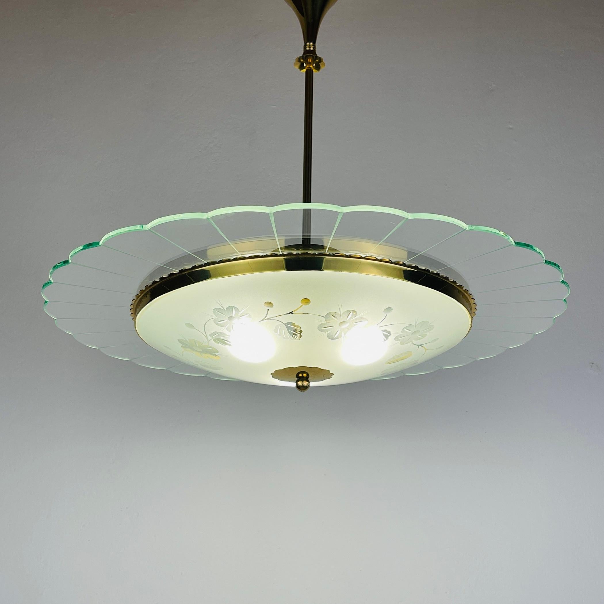 Vintage disk chandelier by Pietro Chiesa for Fontana Arte made in Italy in the 1940s.
Three exquisitely sculpted and sandblasted glass discs interact with light in contrasting manners, offering a captivating display of luminosity and shadow.
Crafted