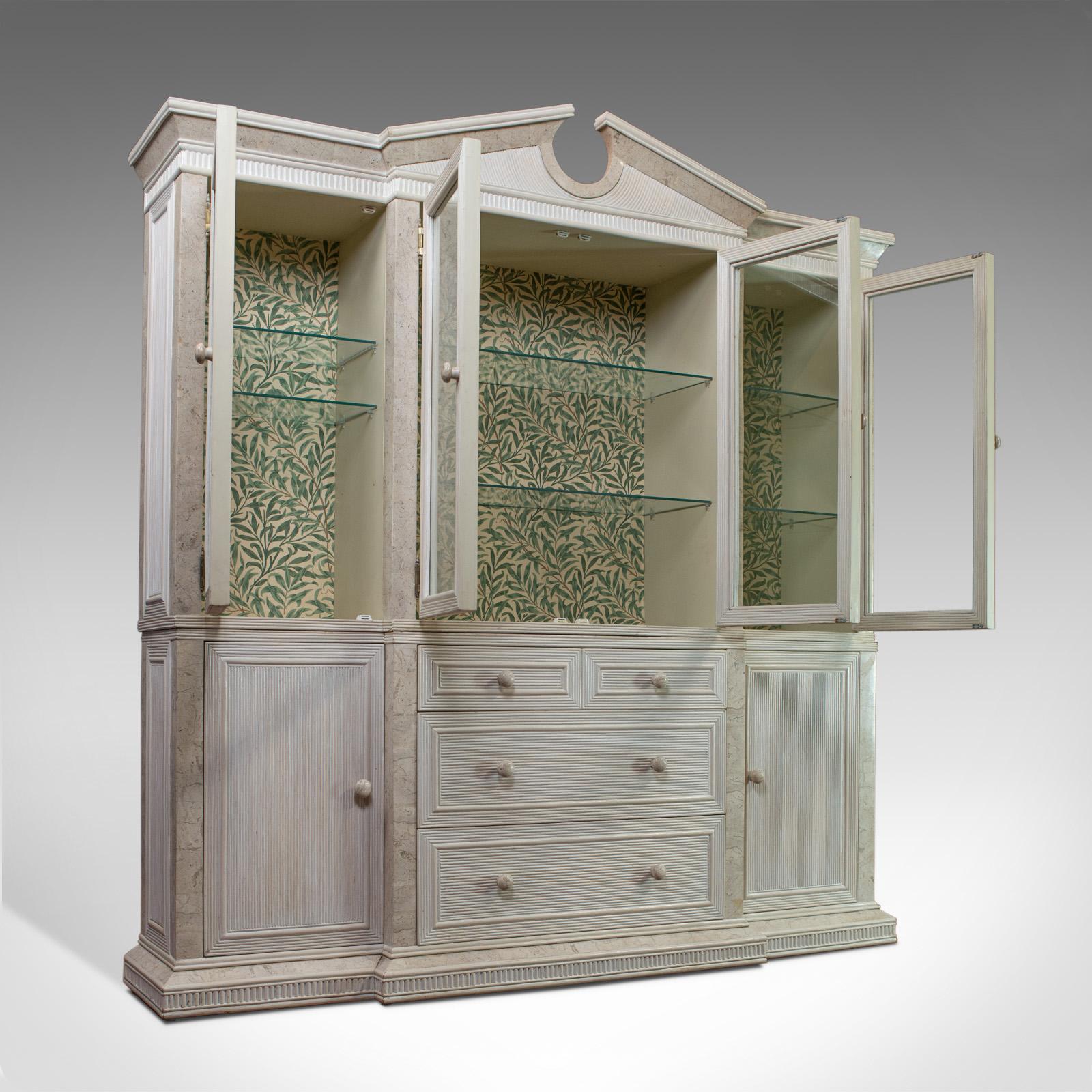 This is a vintage display cabinet. An English, beech and travertine, breakfront cabinet in the classical taste and dating to the late 20th century, circa 1980.

Eye-catching cabinet in generous proportion
Good consistent color