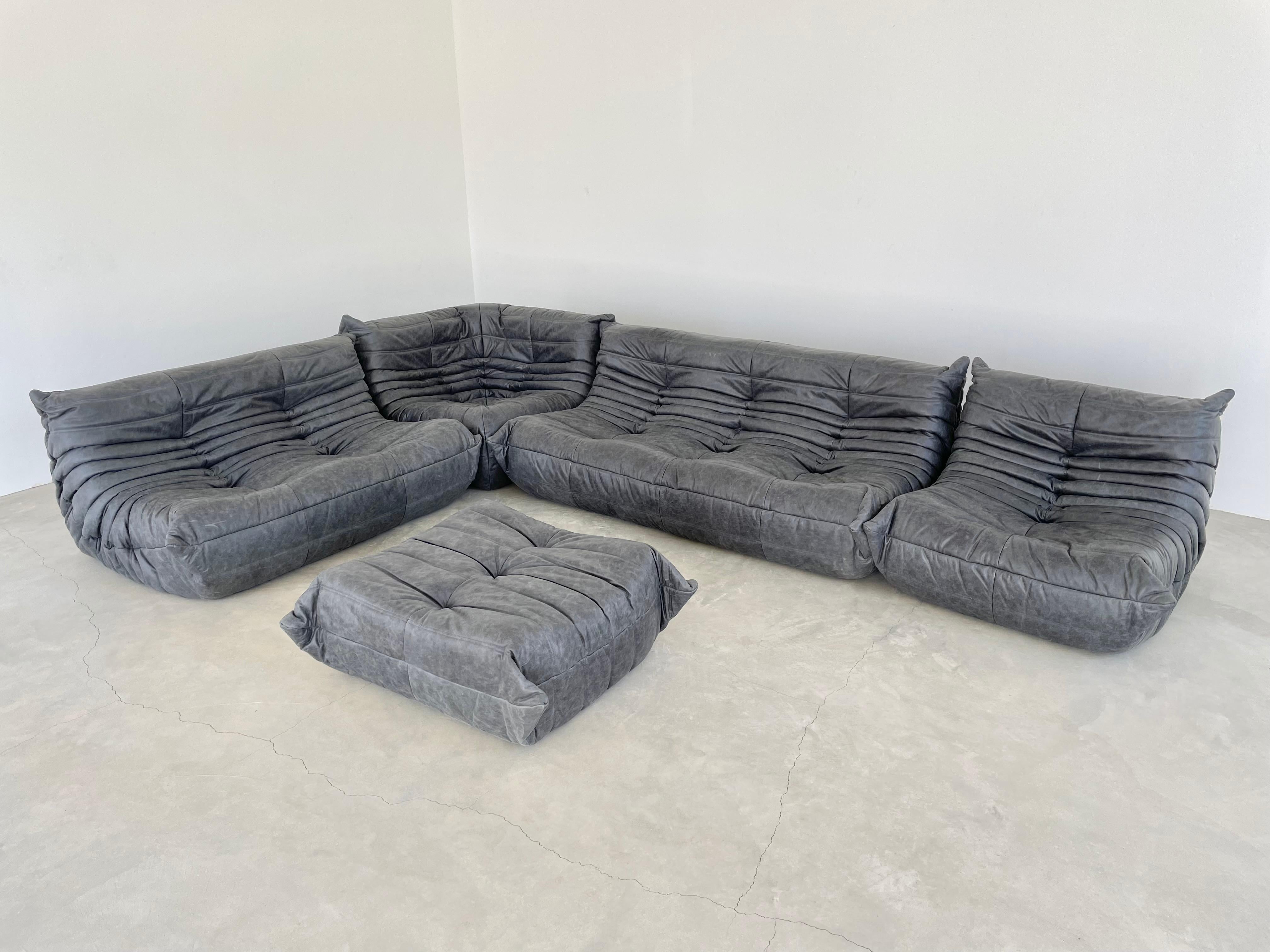 Classic French Togo set by Michel Ducaroy for luxury brand Ligne Roset. Originally designed in the 1970s the iconic togo sofa is now a design classic. This set comes in its original vintage distressed black leather.

Timeless comfort and style make