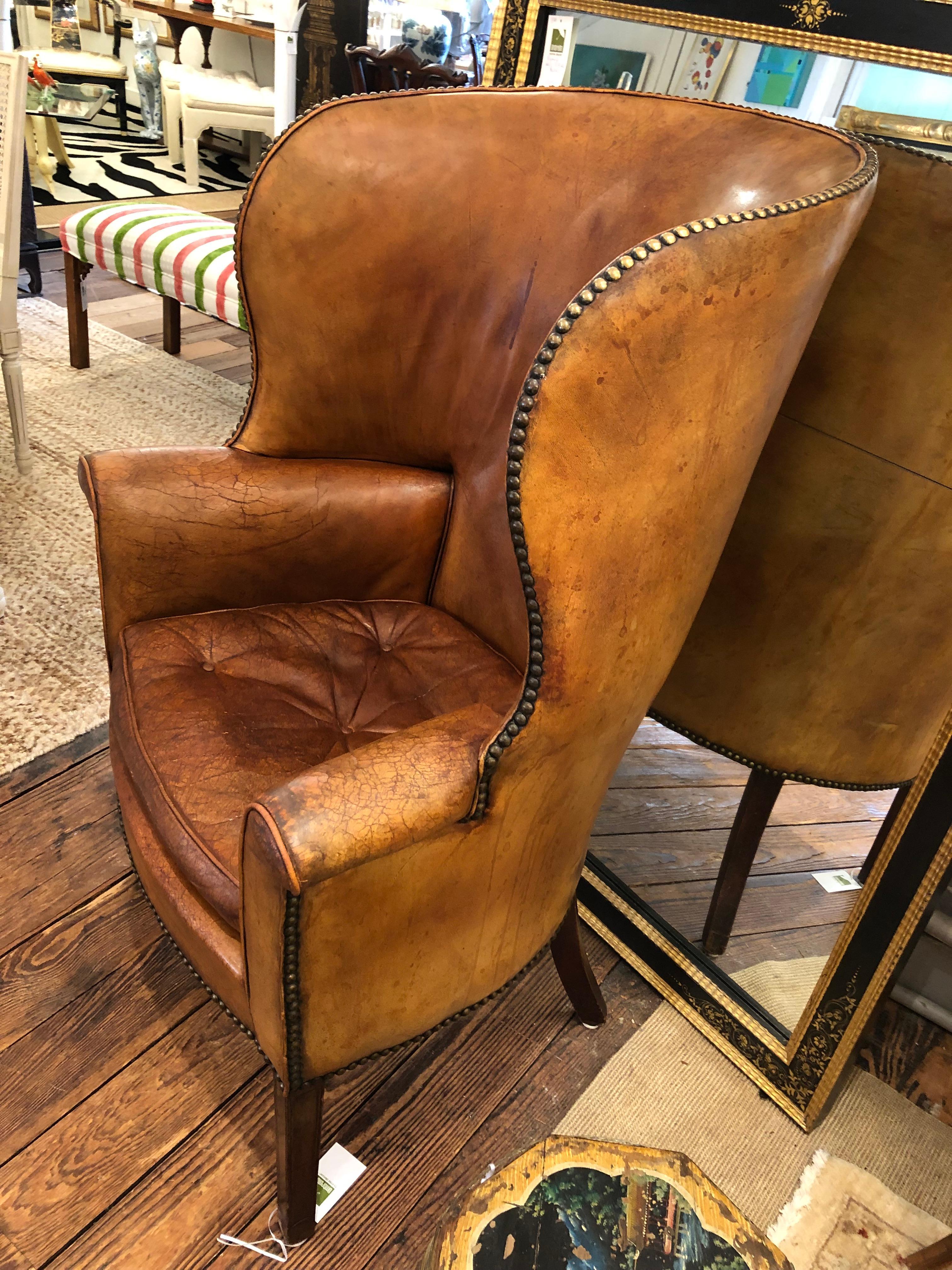 Authentically distressed yummy caramel leather barrel back wing chair having tufted seat cushion and aged brass nailhead details.  They don't come along like this very often.
27 w at top
arm height 27.5
s/h 19.5
s/d 20

Ronda S