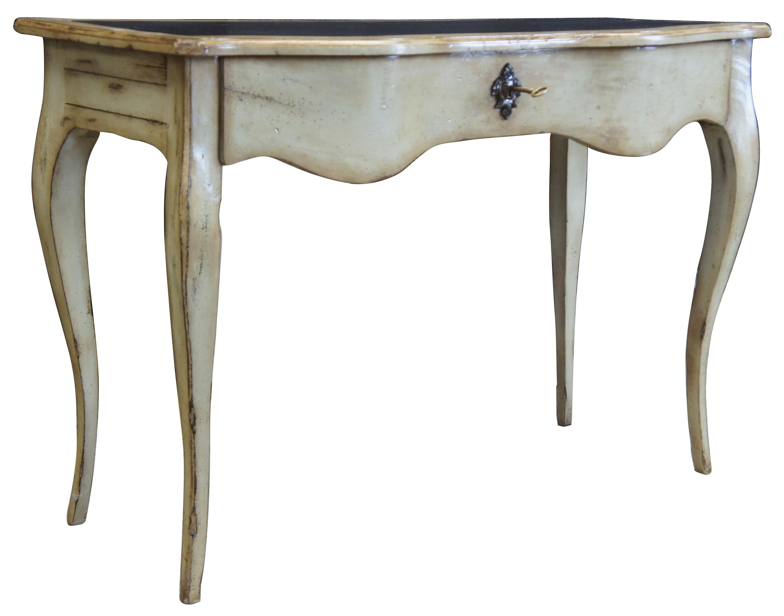 20th century reproduction of a French Oxbow console table. Features a painted oak finish with distressing, inset leather top and large drawer with lock and key. The table is supported by four long cabriole legs.
 