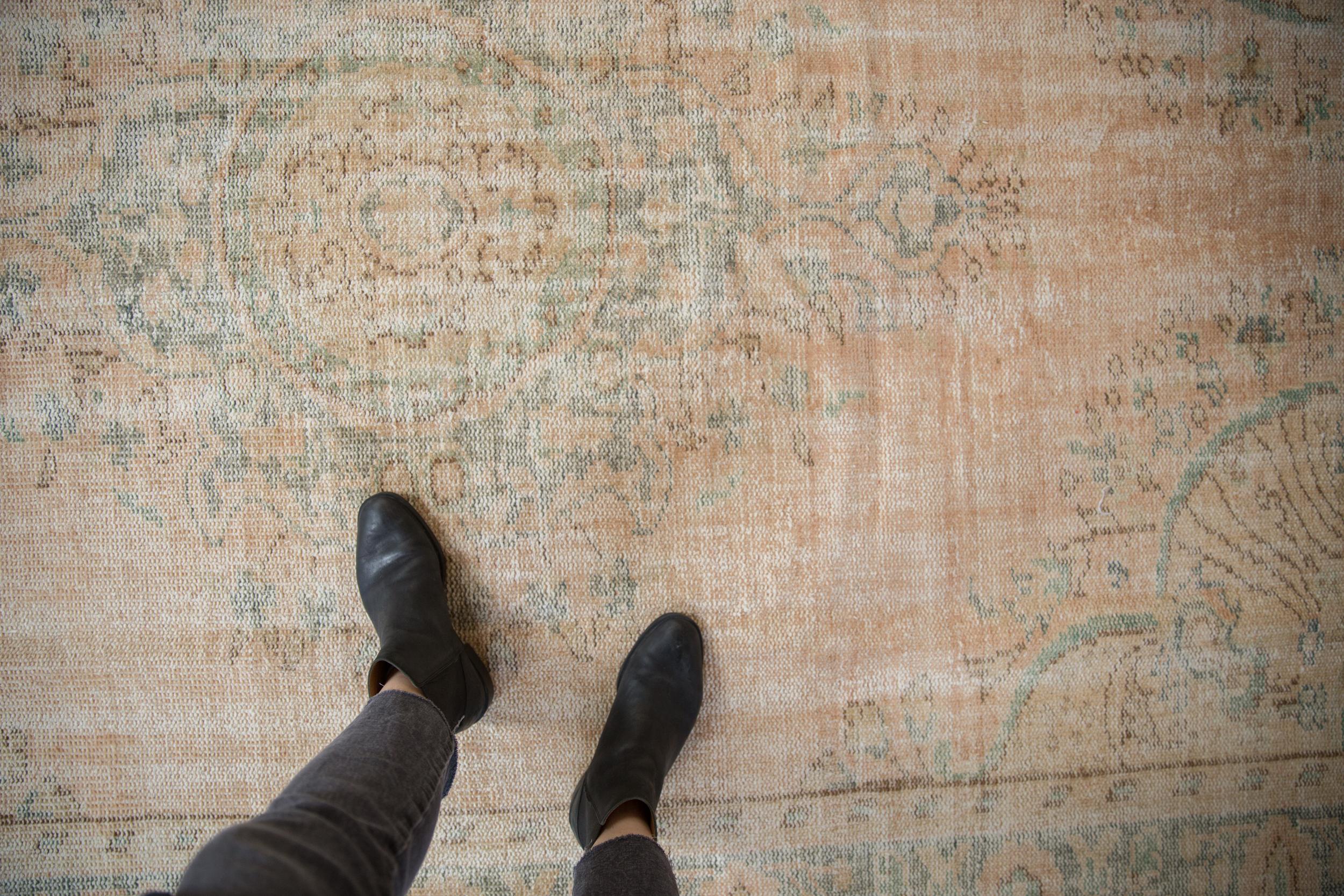 Roundel center medallion with intricate floral blossom bouquets stemming therefrom adorned at either end by trefoil finials atop an open abrashed field and long stemmed blossoms inwardly directed to the center of the carpet from each corner