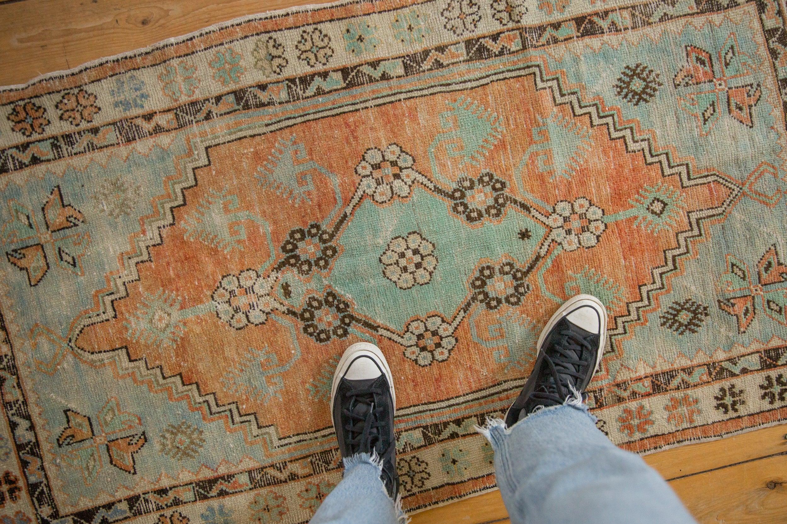 :: Medaglione centrale con viste floreali in alto con fiori a stelo lungo e a voluta in rilievo. Bordo interno minore con arabesco a serpente in rilievo geometrico. Abrashes da una parte all'altra. I colori e le sfumature includono: Terracotta