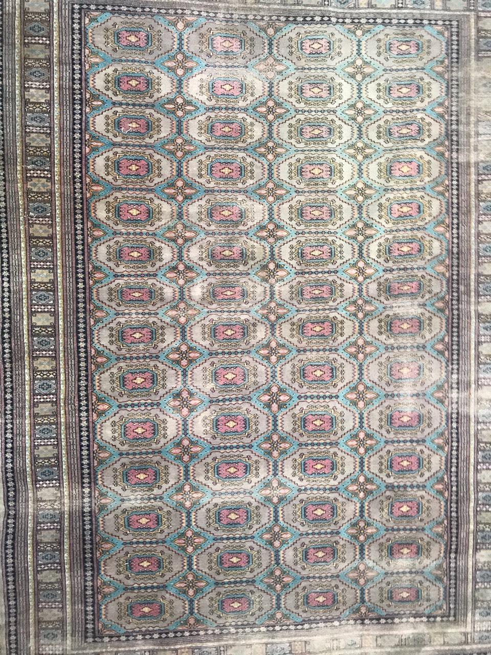 Late 20th century Pakistani rug with a beautiful geometrical Boukhara design with light colors with blue and pink, entirely hand knotted with wool velvet on cotton foundation.