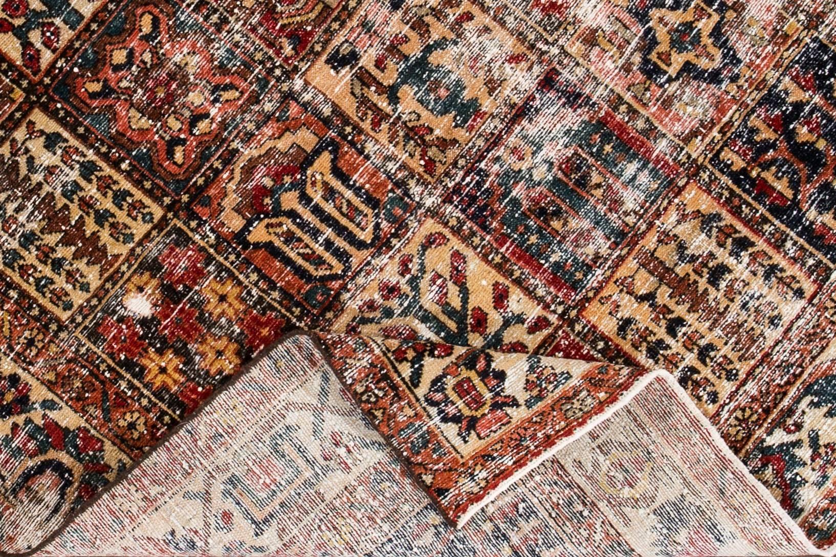 1930s vintage, square-shaped Persian Tabriz carpet. This distressed piece features a geometric, quilt-style design accented in rust, blues, and earth tones. Measures: 5.03 x 6.08.