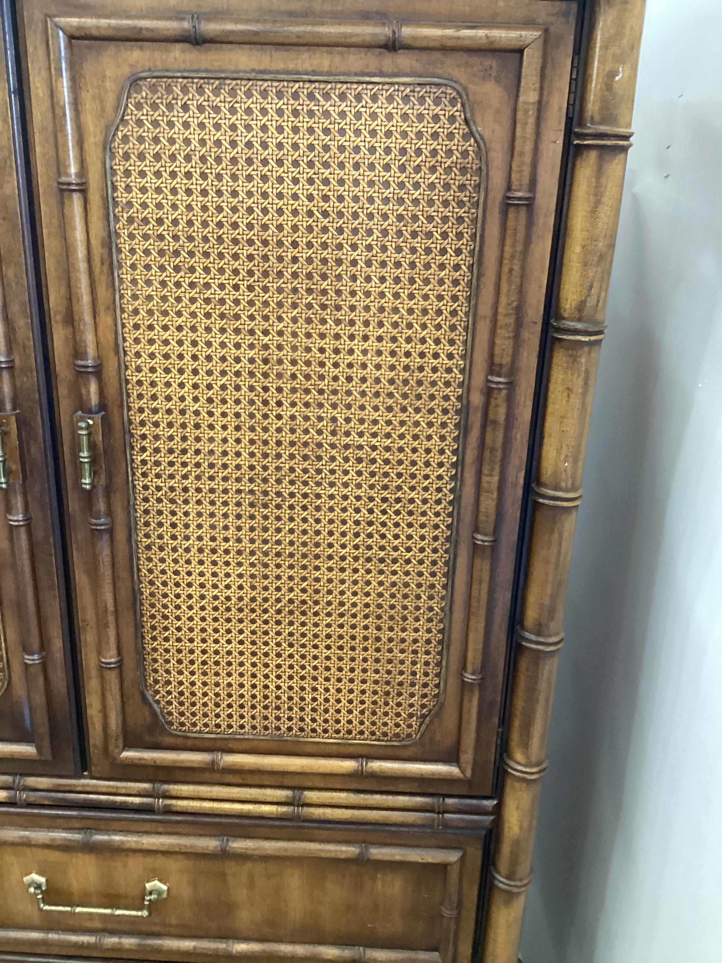 Vintage Dixie Furniture Fruitwood and Rattan Armoire. Great storage furniture . The double doors open to reveal ample storage with drawers and compartments for more storage. Please reach out for cheaper shipping options.