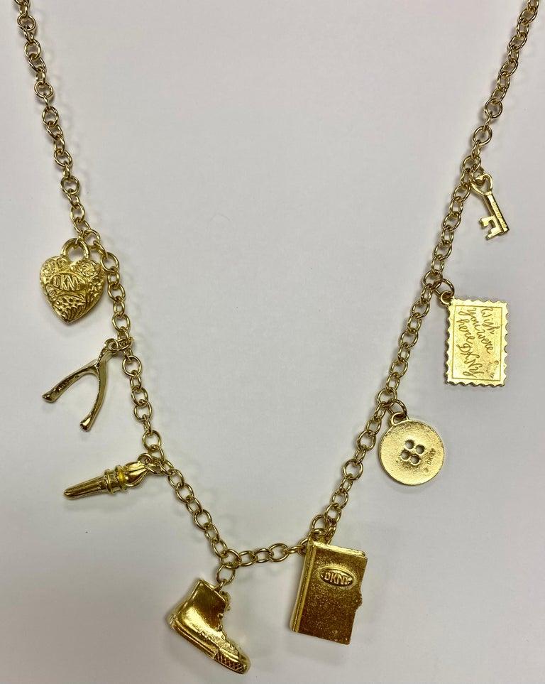 Awesome Vintage Signed Donna Karan Multi Charm Matte Gold Tone Link Necklace. Approx. 34” Long. Excellent unworn Condition. Circa: 1990s. Matching Bracelet available in listings. Chic and Fun to Wear…Sure to be admired! The perfect accessory for the