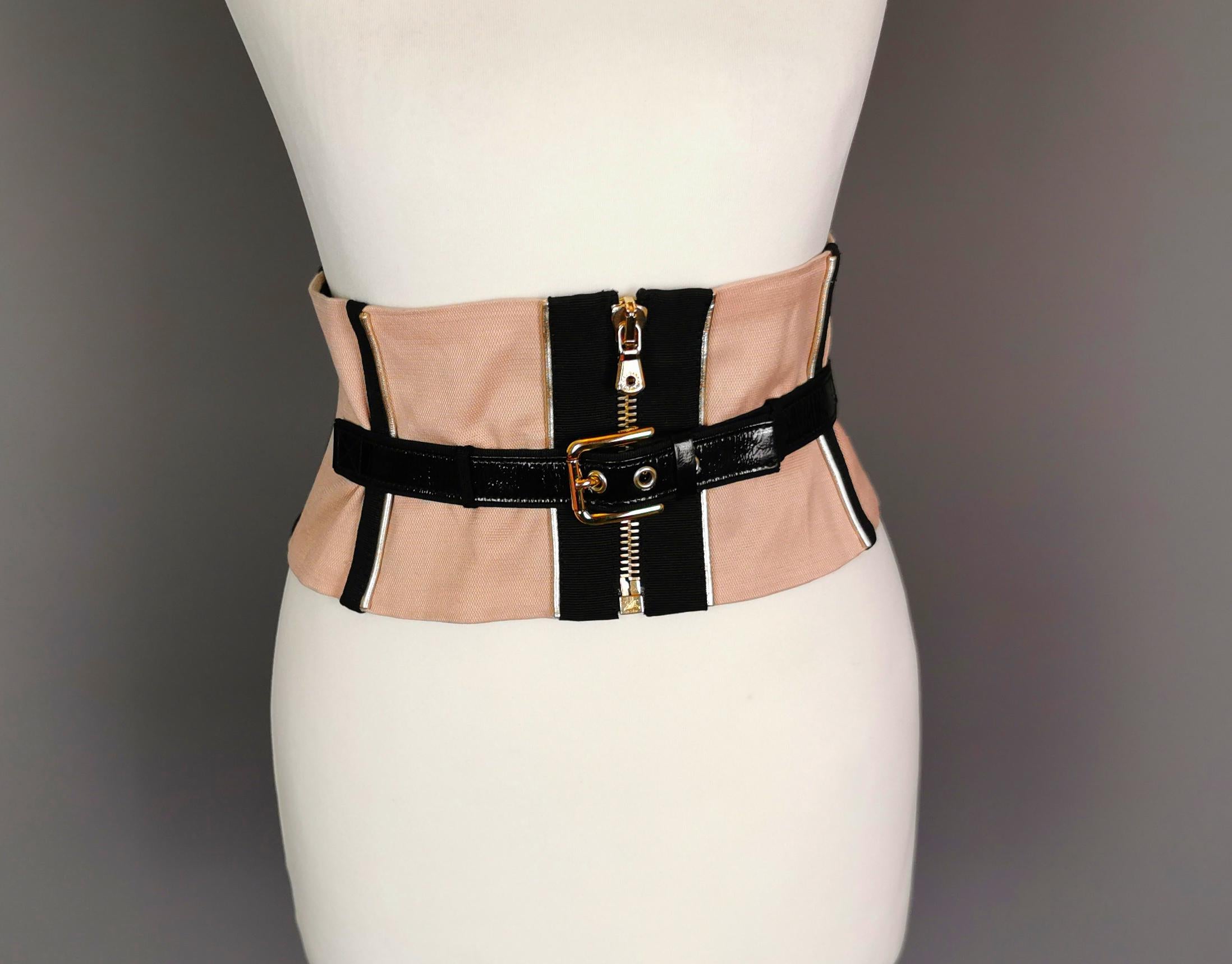 A stunning and iconic corset style waist belt by Dolce and Gabbana.

This belt is one of those pieces that literally turns any outfit into a glam masterpiece in five minutes.

Incredibly well designed, it is finished in a blush pink colour with inky