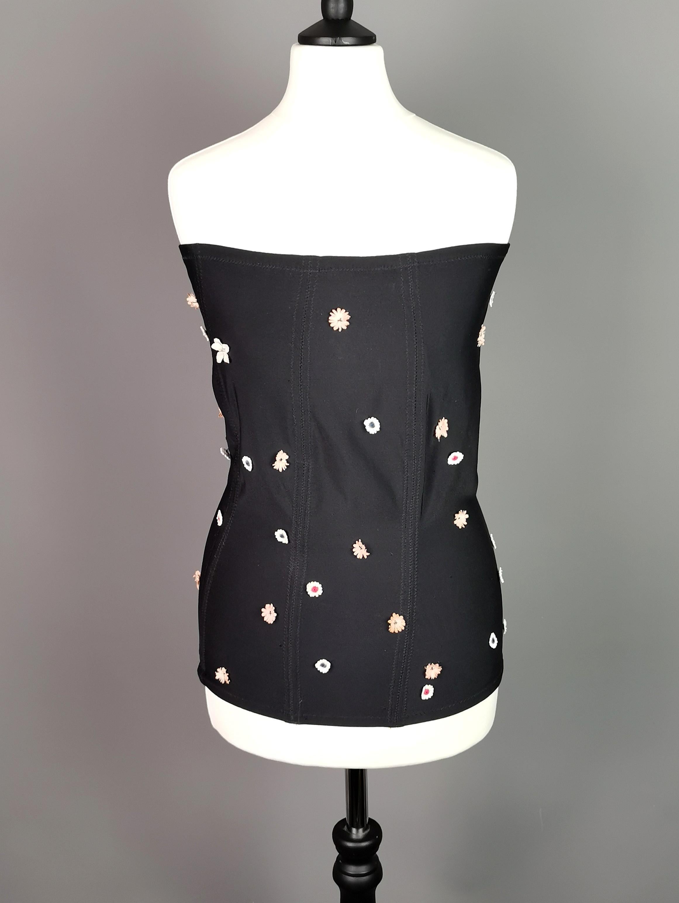 A gorgeous and unusual vintage Dolce and Gabbana floral corset or bandeau top.

It is a longer length top, very figure hugging and tight fitting it is black with a ditsy floral embellished design.

Tiny little flowers are spread across the garment