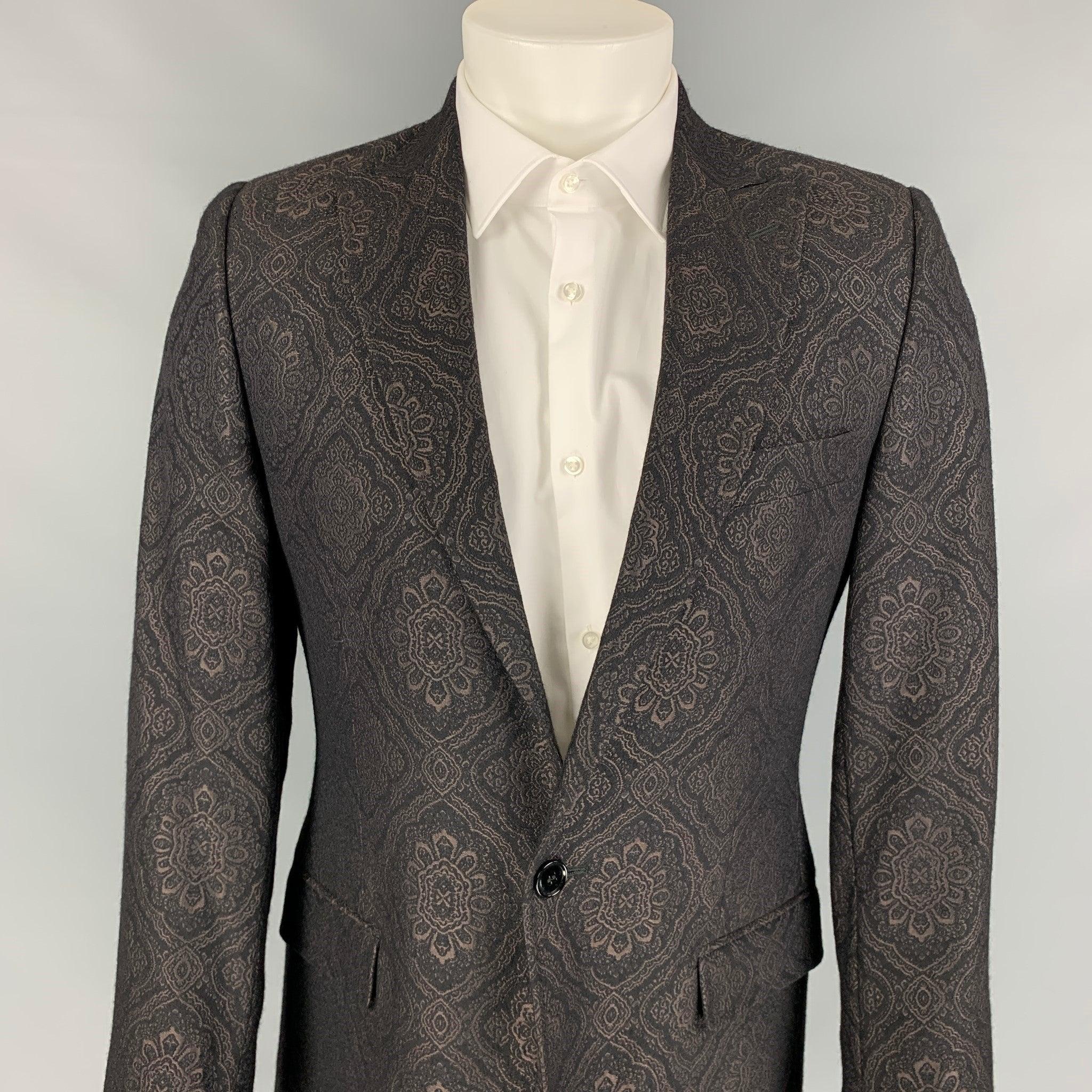 Vintage DOLCE & GABBANA sport coat comes in a black jacquard wool / silk with a full liner featuring a peak lapel, flap pockets, single back vent, and a single button closure.
Made in Italy. Very Good Pre-Owned Condition. 

Marked:   48
