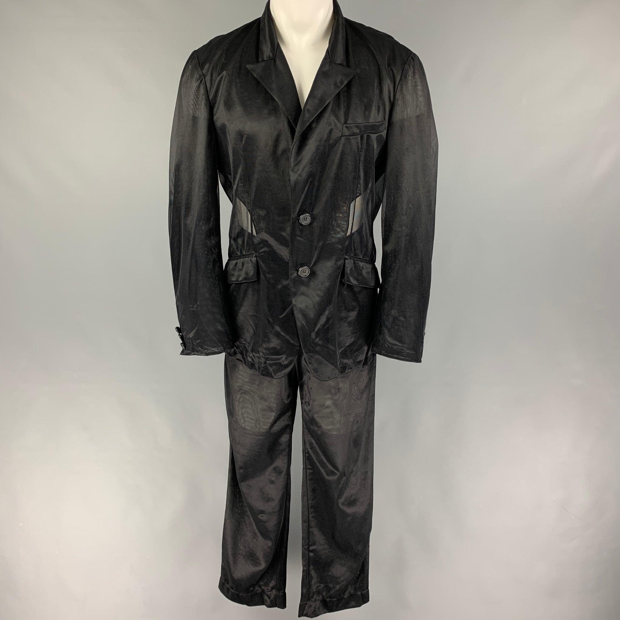 Vintage DOLCE & GABBANA
suit comes in black see-through polyamide and includes a single breasted, double button sport coat with a peak lapel and matching flat front trousers. Made in Italy. Good Pre-Owned Condition. 

Marked:   52 

Measurements: 
 