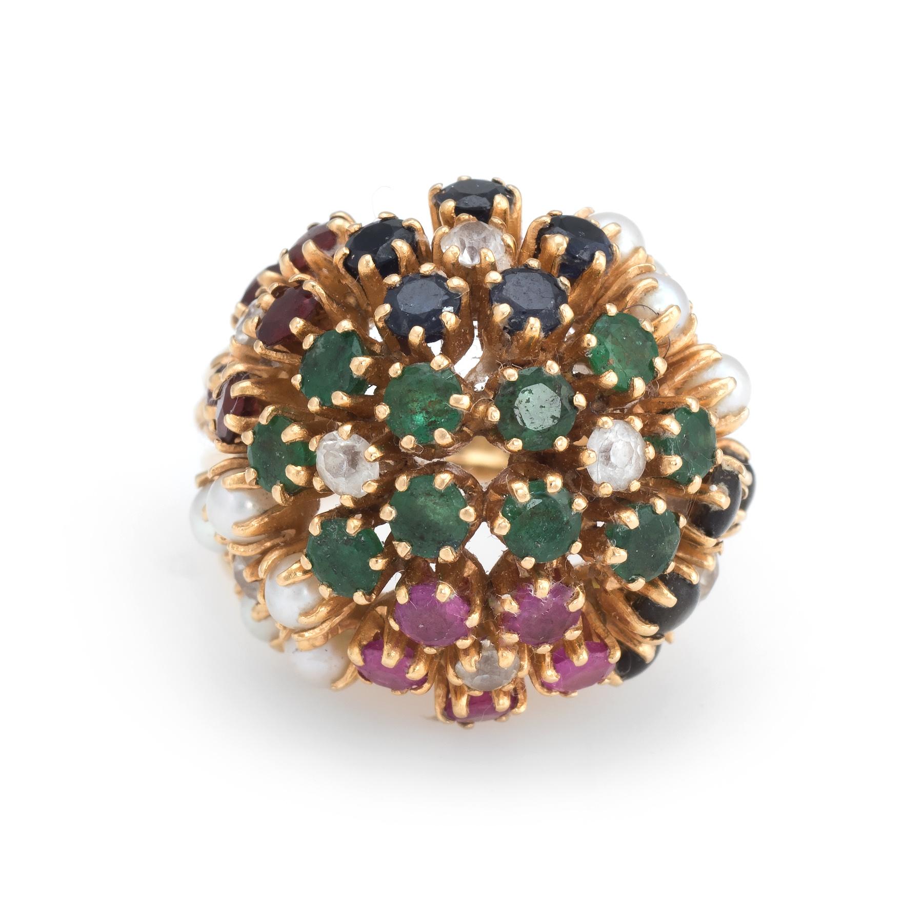 Finely detailed vintage domed cocktail ring (circa 1960s to 1970s), crafted in 18 karat yellow gold. 

Rubies, emeralds & sapphires measure 2mm each (estimated at 0.05 carats each). Seed pearls each measure 2mm and synthetic white stones measure