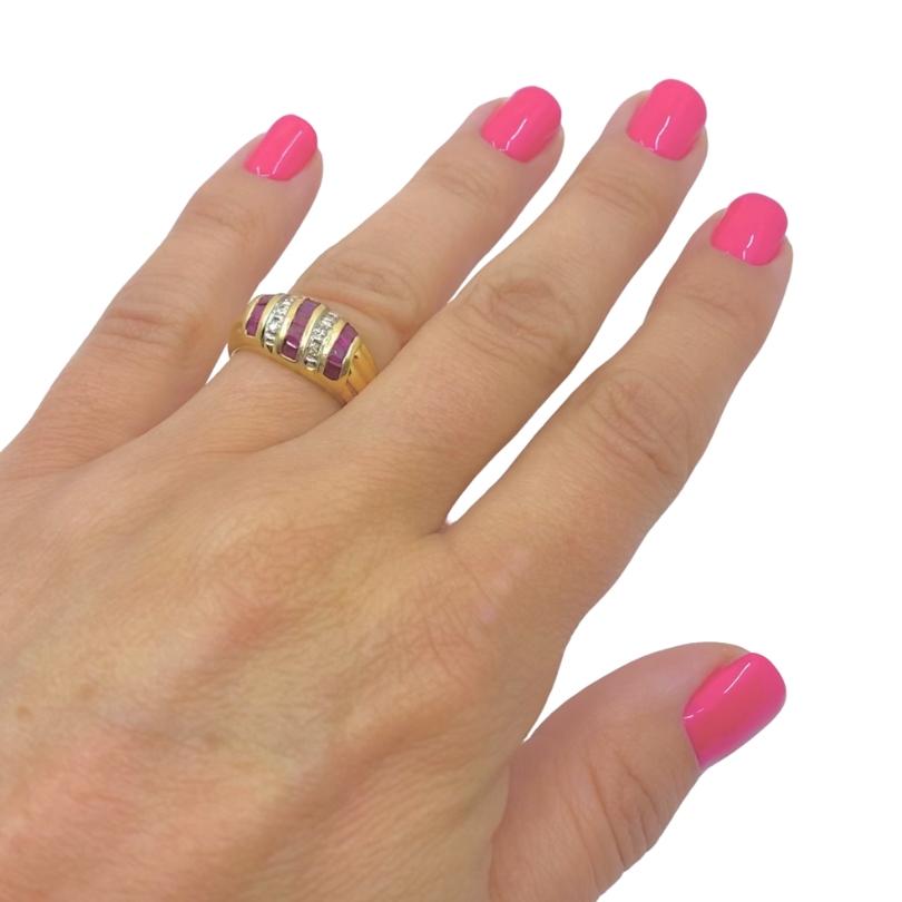 

A beautiful vintage dome ring, crafted in 18k gold, features diamonds and rubies.
The domed part has a striking pattern of channel set rubies and diamonds. Three rows of rectangular rubies alternate with two glittering rows of round cut diamonds,