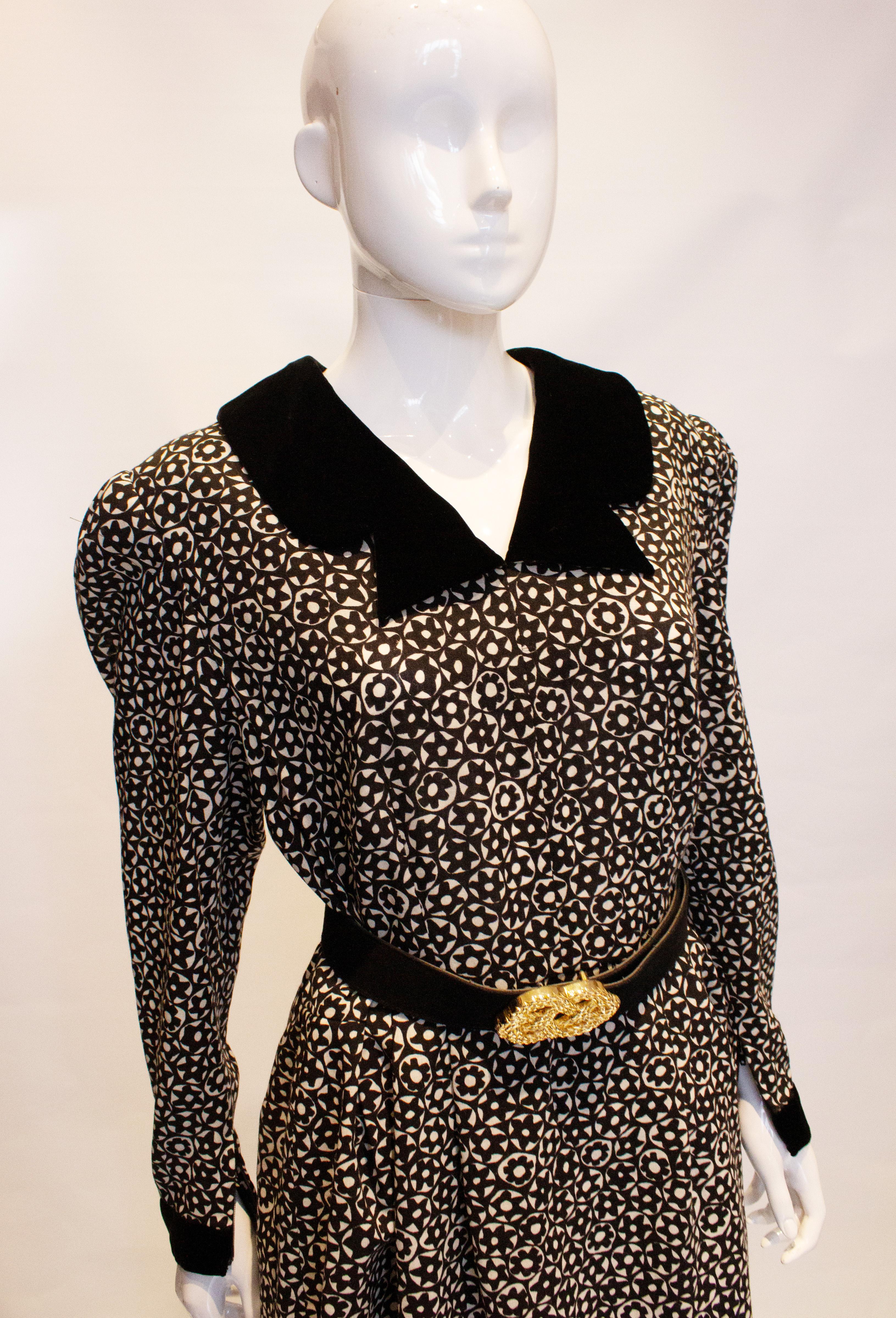 A chic vintage day dress by Donald Campbell. In a black and white wool print, the dress has an interesting velvet cut away collar and cuffs. It is fully lined with a central back zip.
Measurements: Bust 40'',  waist 29'', length 42'', size 14