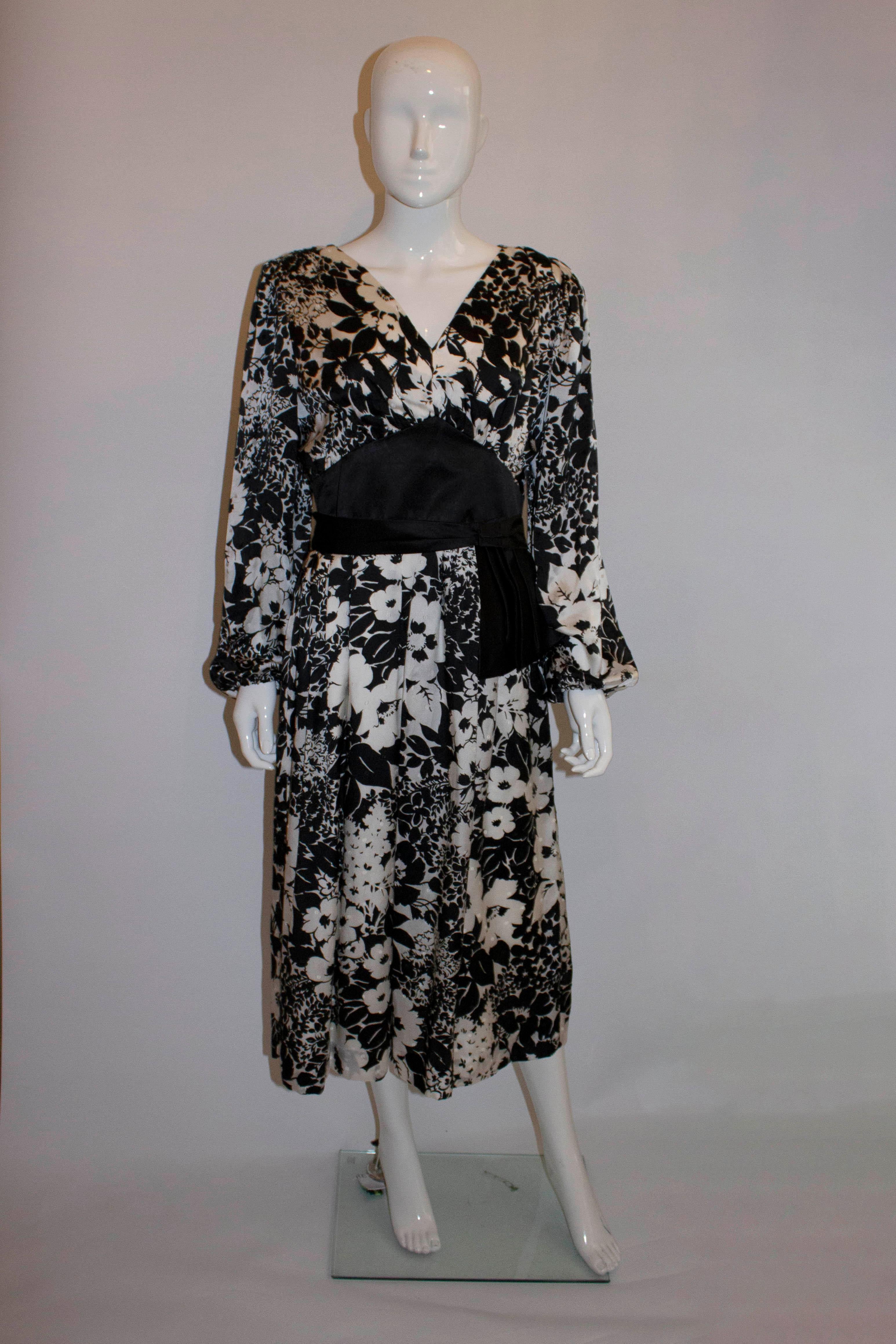 Ein atemberaubendes Vintage-Seidenkleid von Donald Campbell. Das Kleid mit hübschem schwarz-weißem Print und Struktur hat einen V-Ausschnitt mit Schärpe, Raffungen an den Schultern, elastische Bündchen und einen zentralen Reißverschluss