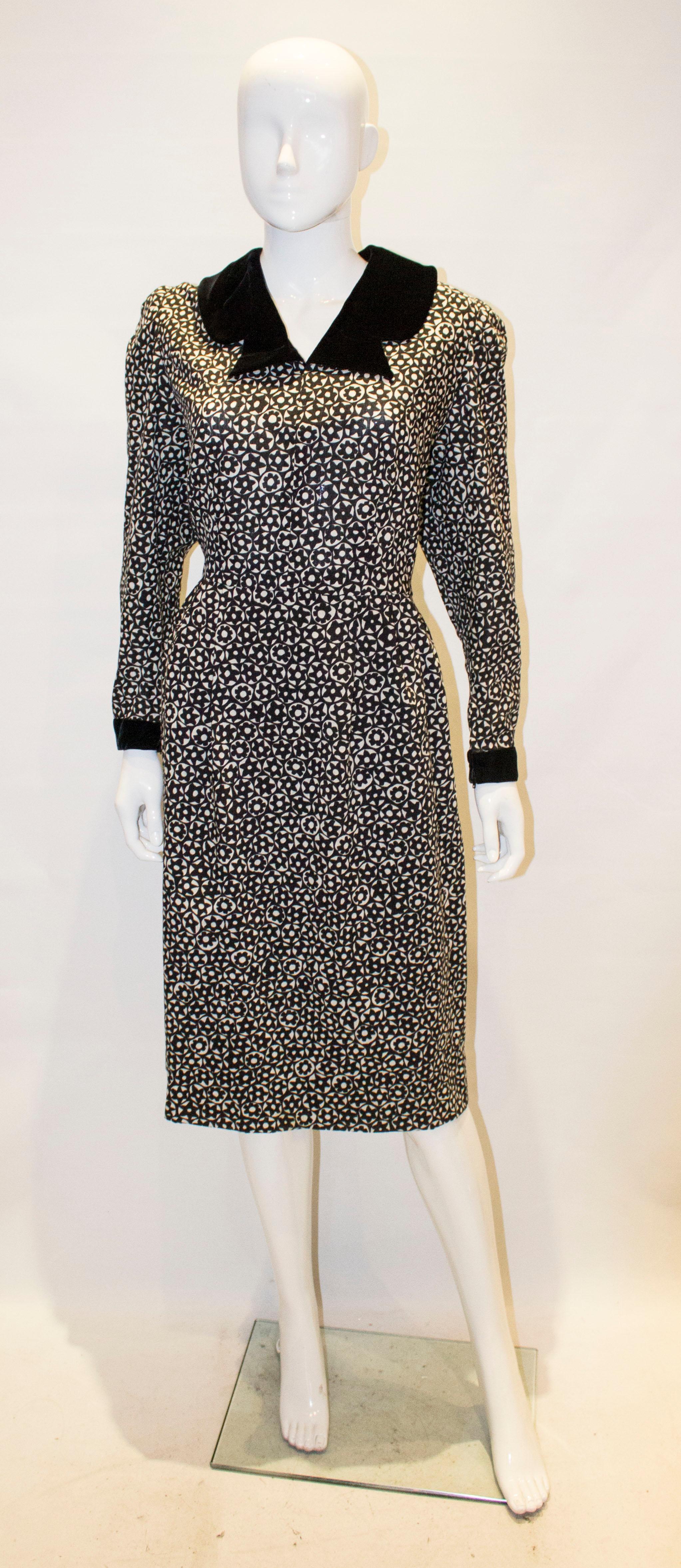A chic vintage dress  by Donald Campbell. The dress is in a black and white wool print with interesting velvet cut away collar and cuff.s It has a central back zip, and is fully lined .

