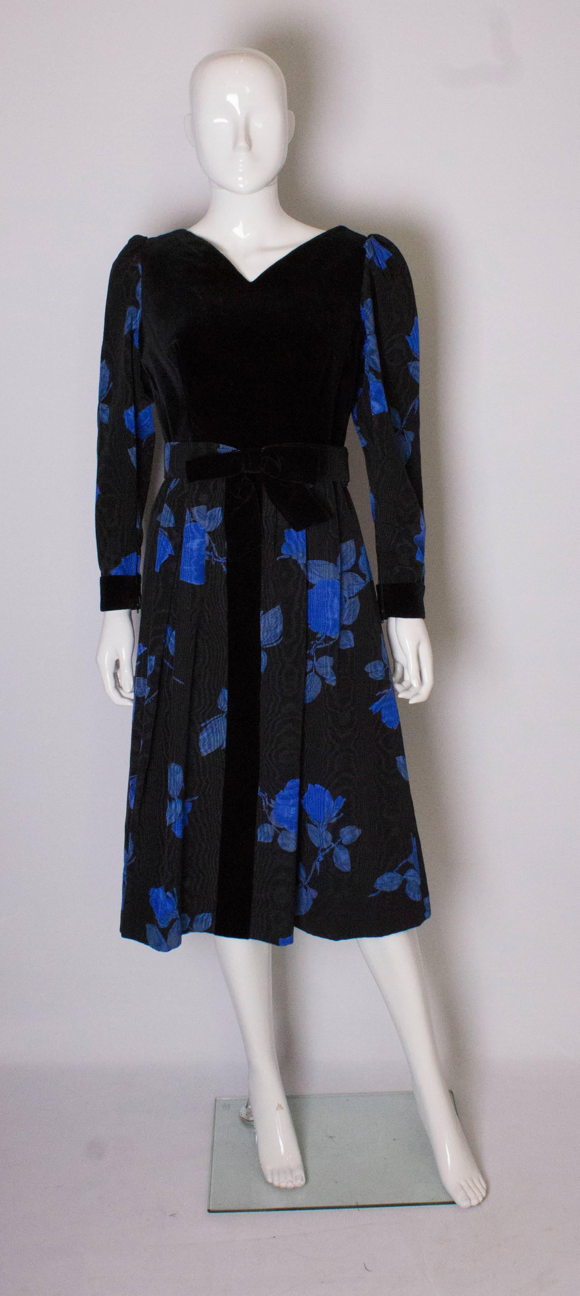 A chic vintage cocktail /dinner dress by Donald Campbell. The dress has a velvet body , with a v neckline front and back. It has a central back zip, and central velvet strip down the front. The skirt is moire silk and fully lined. It has elbow
