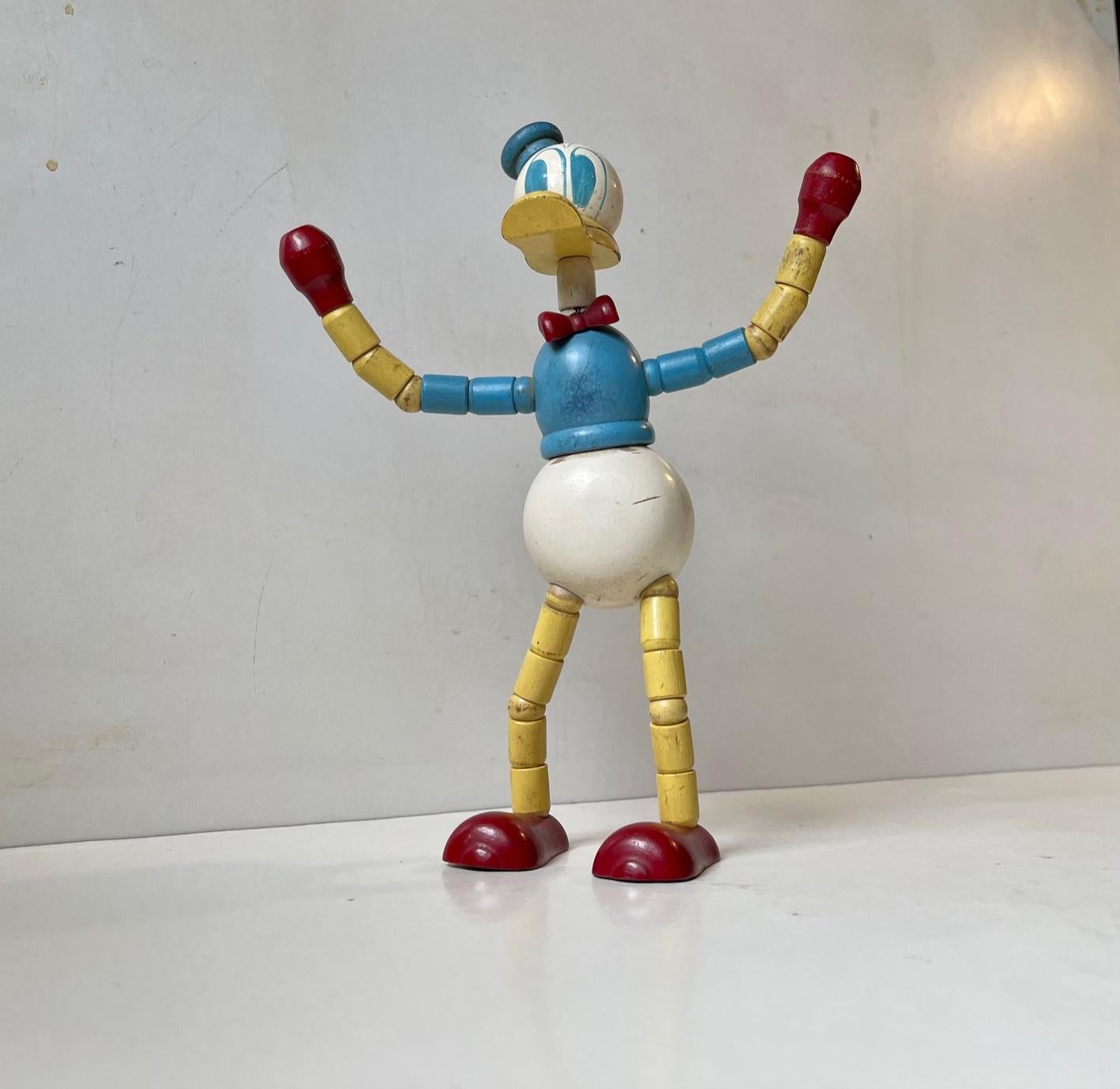 A Walt Disney licensed old wooden Donald Duck with articulated limbs/joints. It was made by BRIO in Sweden from 1938. This version in painted Beech dates from the 1940s. It can be used decoratively or to display your businesscard. Measurements: