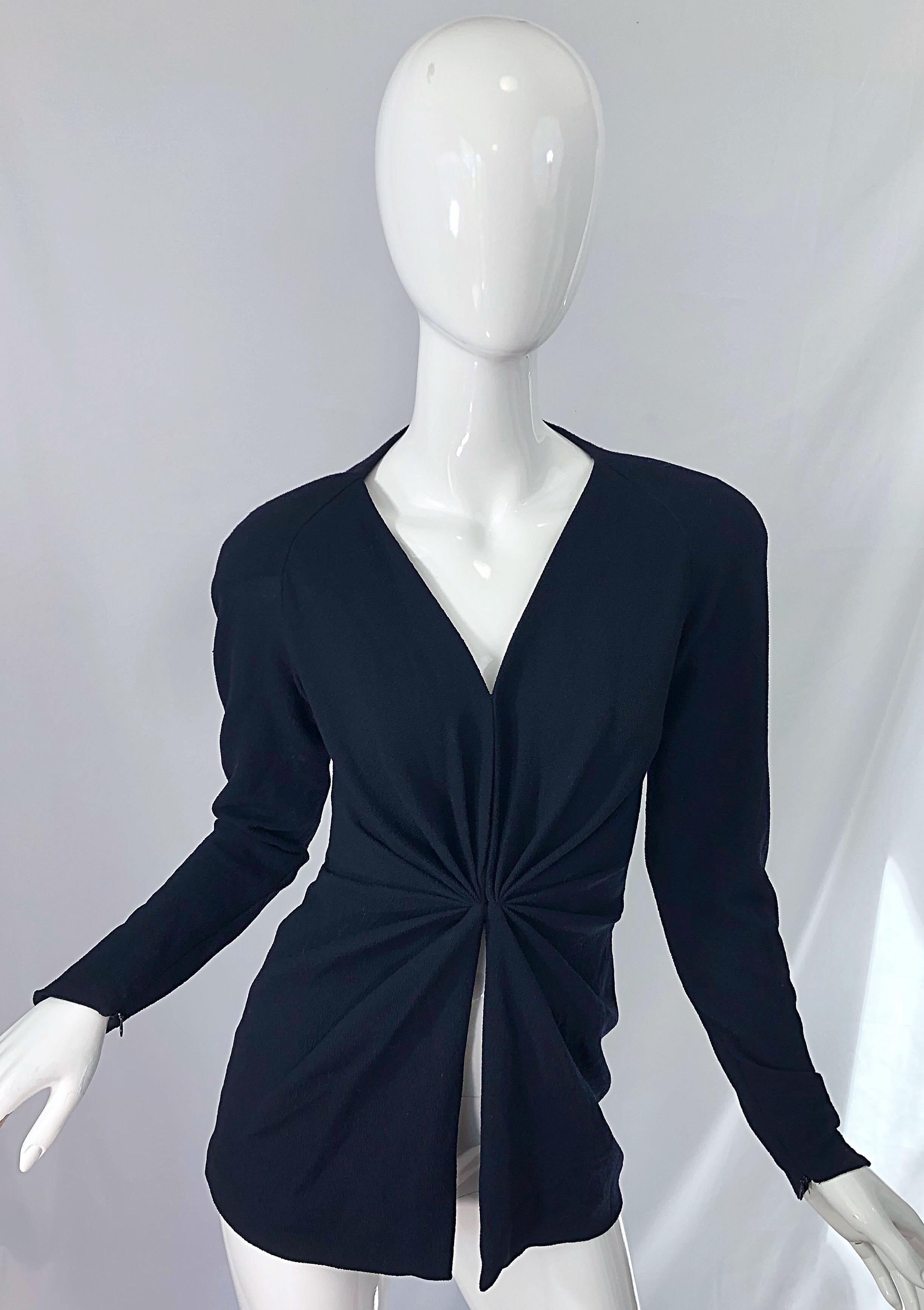 Classic, with a sexy edge early 1990s DONNA KARAN Collection black crepe top ! Features flattering ruching at waist. Hook-and-eye closures down the front. Interior elastic waistband allows for comfort and ease. Hidden zippers at each sleeve cuff.