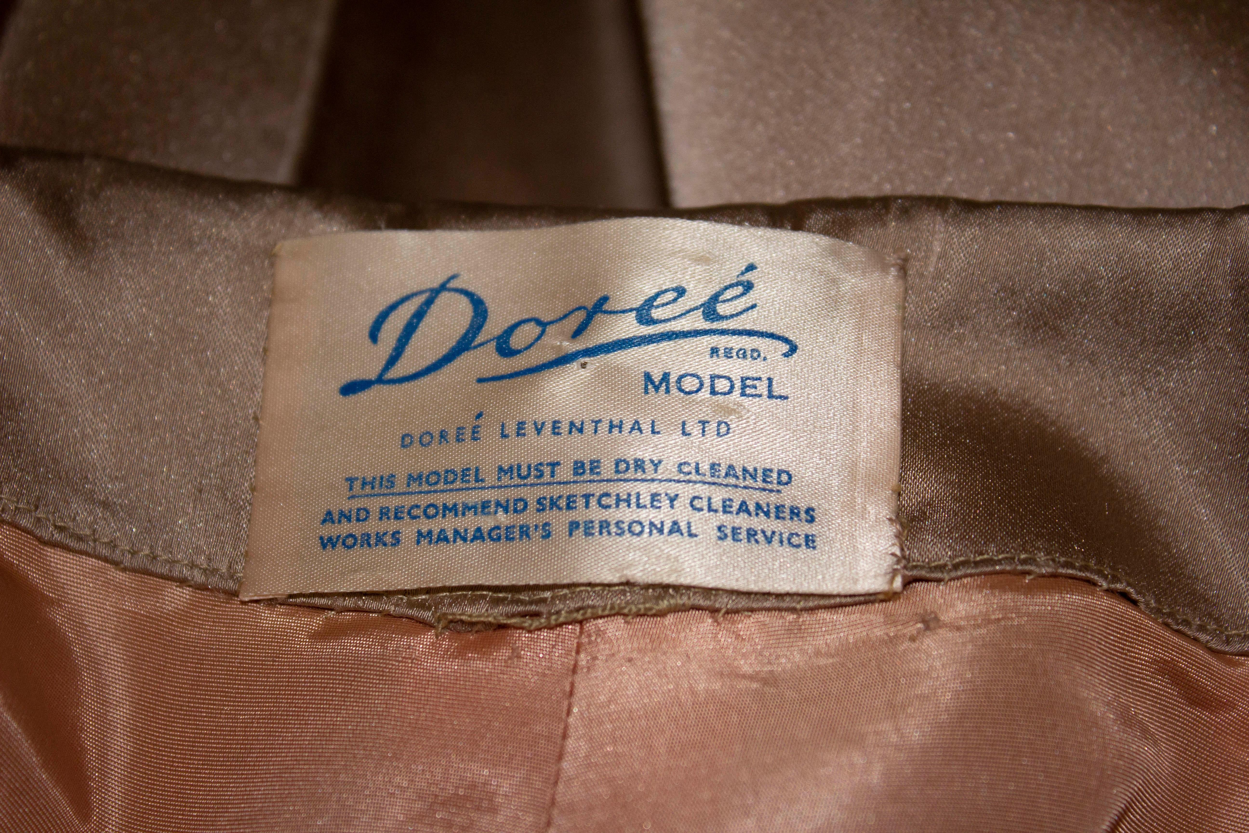 Ein schicker Vintage-Mantel von Doree Leventhal, dieser Satinmantel ist in einem sanften Goldton gehalten, hat einen angeschnittenen Kragen und eine Halskrawatte, ist A-Linie und vollständig gefüttert.
Maße; Büste bis zu 52'', Länge 40''