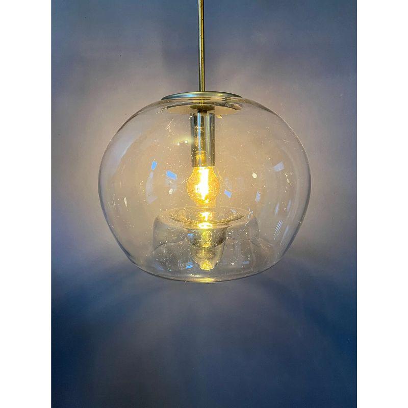 Very rare glass pendant the German Doria Leuchten. The hand-made glass is beautifully shaped with a bulb-movement underneath. The lamp may look dirty on the pictures, but these are really very small air-bulbs in the glass.

Dimensions:
ø Shade: