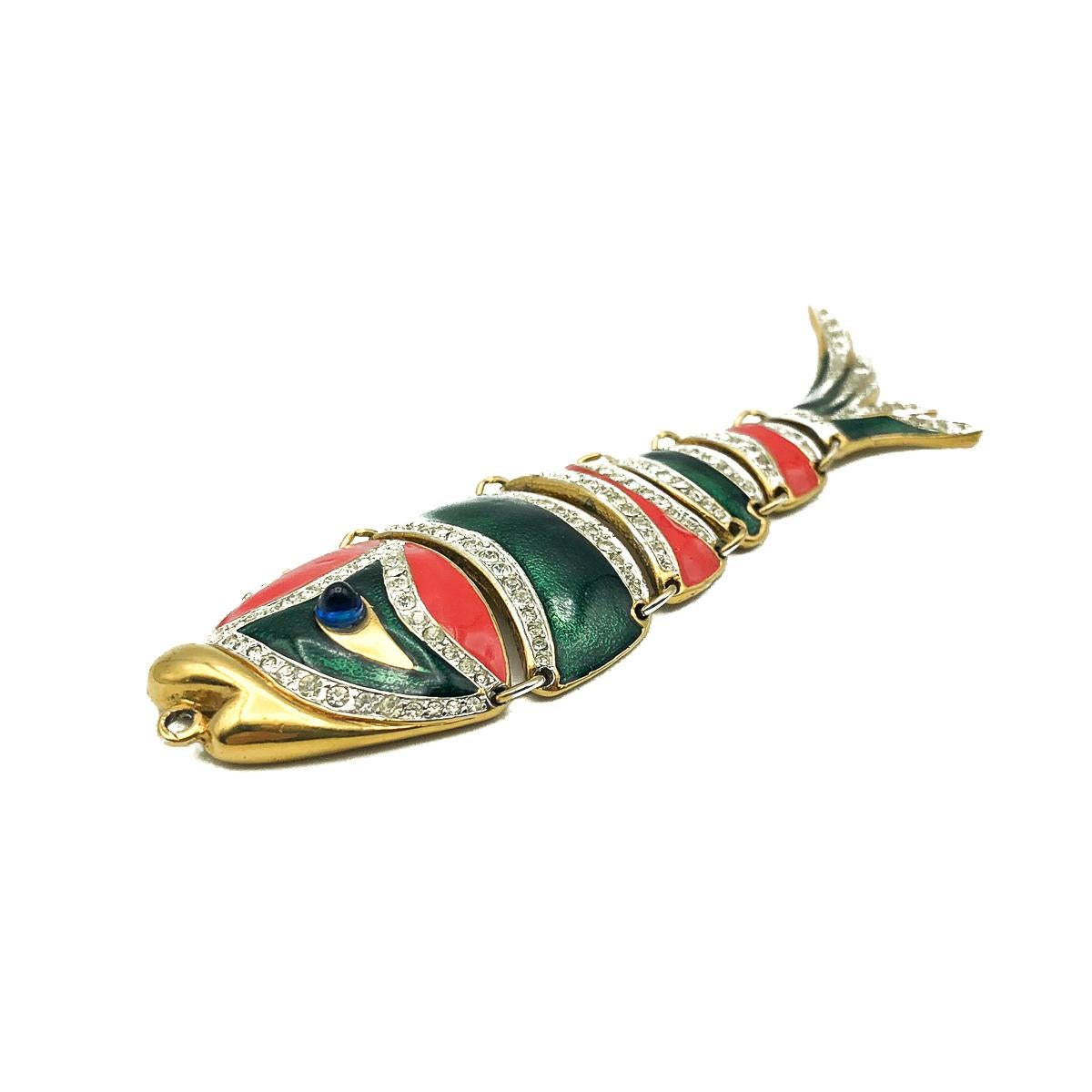 A stunning and quirky Vintage D'Orlan Enamel Fish Necklace. Crafted in gold plated metal and adorned with red and green enamelling, white crystal detail and a gorgeous blue glass cabochon for the eye. The articulation providing perfect movement when