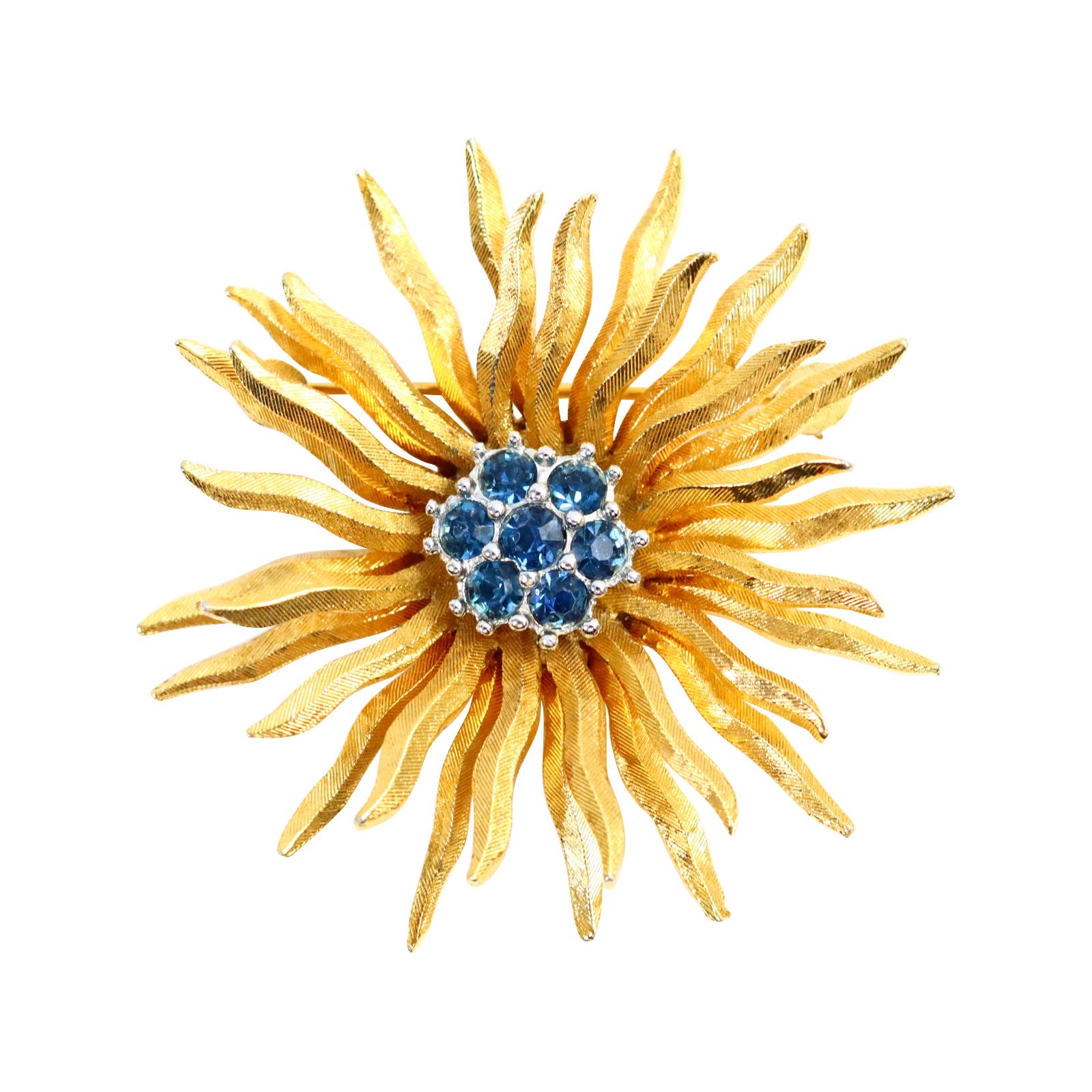 Vintage D'orlan Gold Starburst with Blue diamante set in Silver Circa 1980s. This brooch looks so chic due to its juxtaposition with the gold and then the blue set in silver tone metal in the middle. It is heavy and substantial and gives the air of
