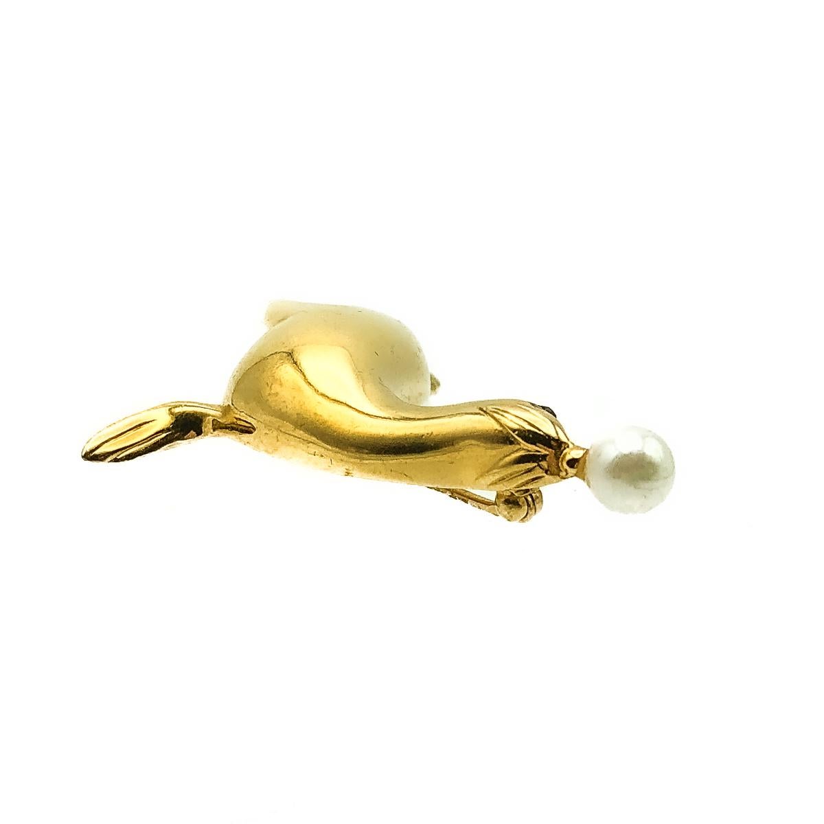 Vintage D'Orlan Sea Lion Brooch. Crafted in gold plated metal and faux simulated pearl. A super shiny sea lion balances a full pearl on his nose. In very good vintage condition, signed and approx. 5cm. A perfect whimsical pin for the animal lover. 