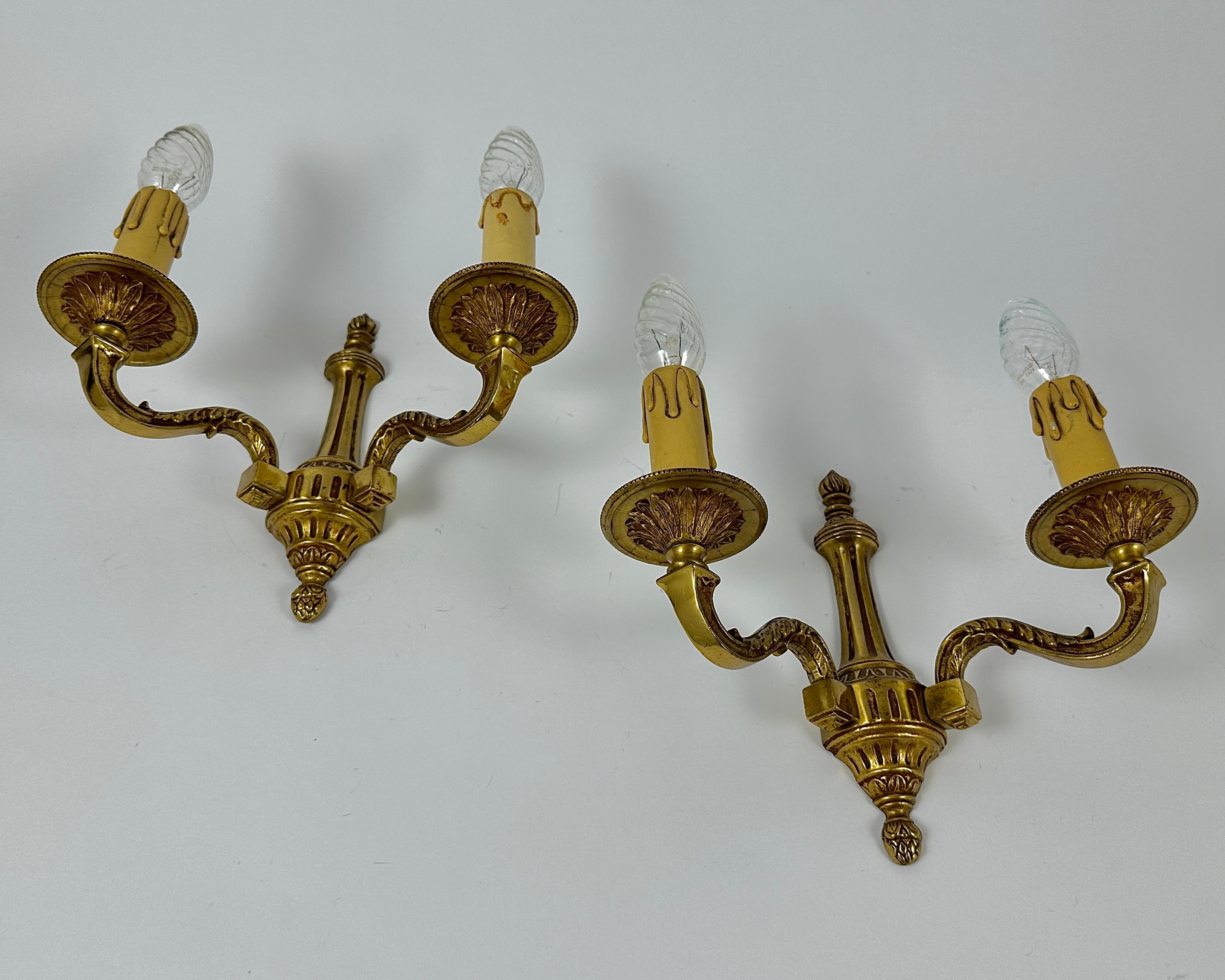 Magníficos apliques de bronce de dos brazos que imitan los candelabros clásicos.  

El diseño de la luminaria contiene elementos de estilo barroco. 

Los bellos detalles de bronce fundido están decorados con motivos tridimensionales de estructura