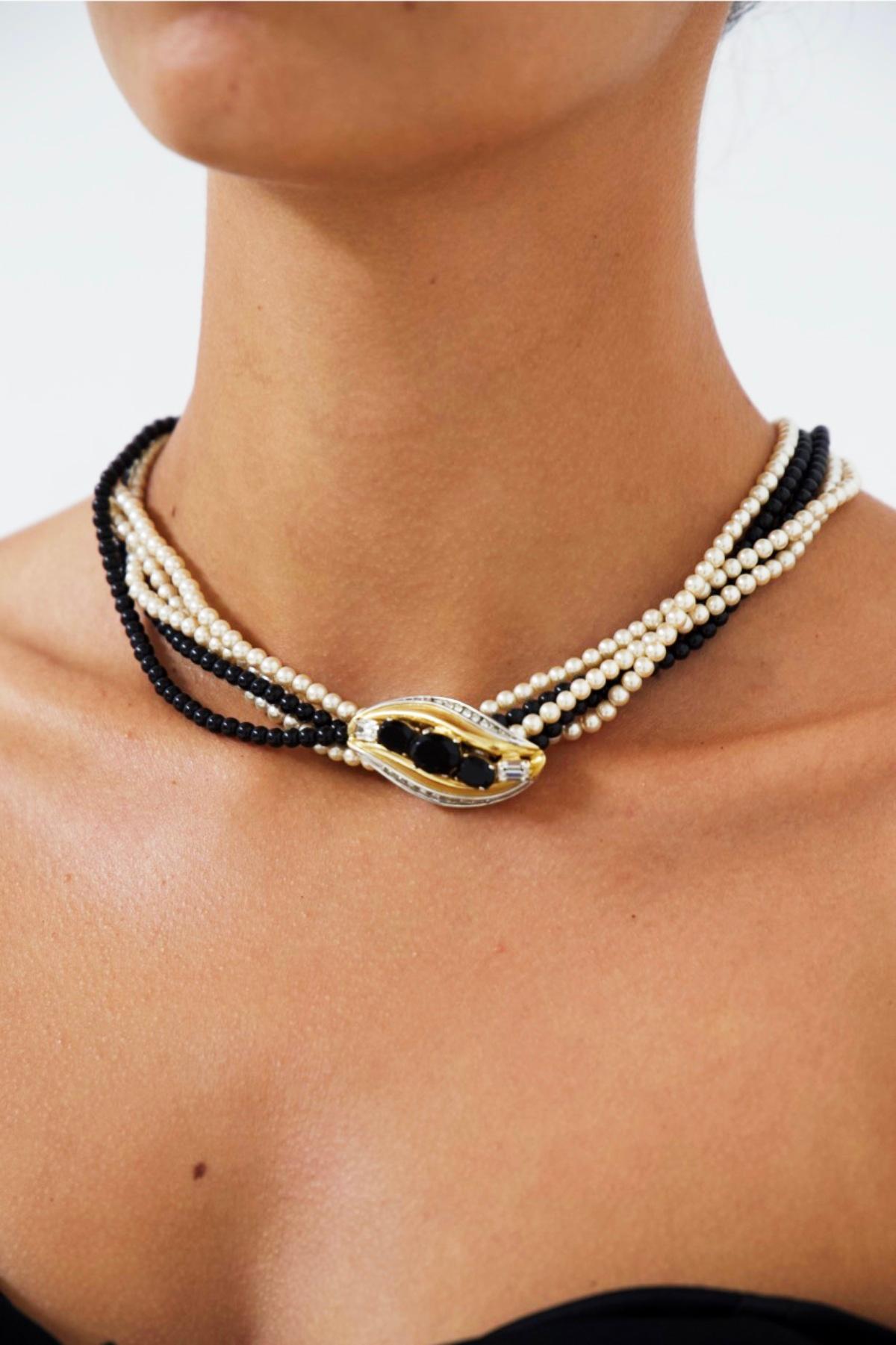 Superb double pearl choker made in the 1980s, fine French craftsmanship.
The necklace is wonderful and elegant.
It is made with 2 strands of black pearls and three white ones, very elegant. Centrally it shows a jewel, the highlight of the necklace: