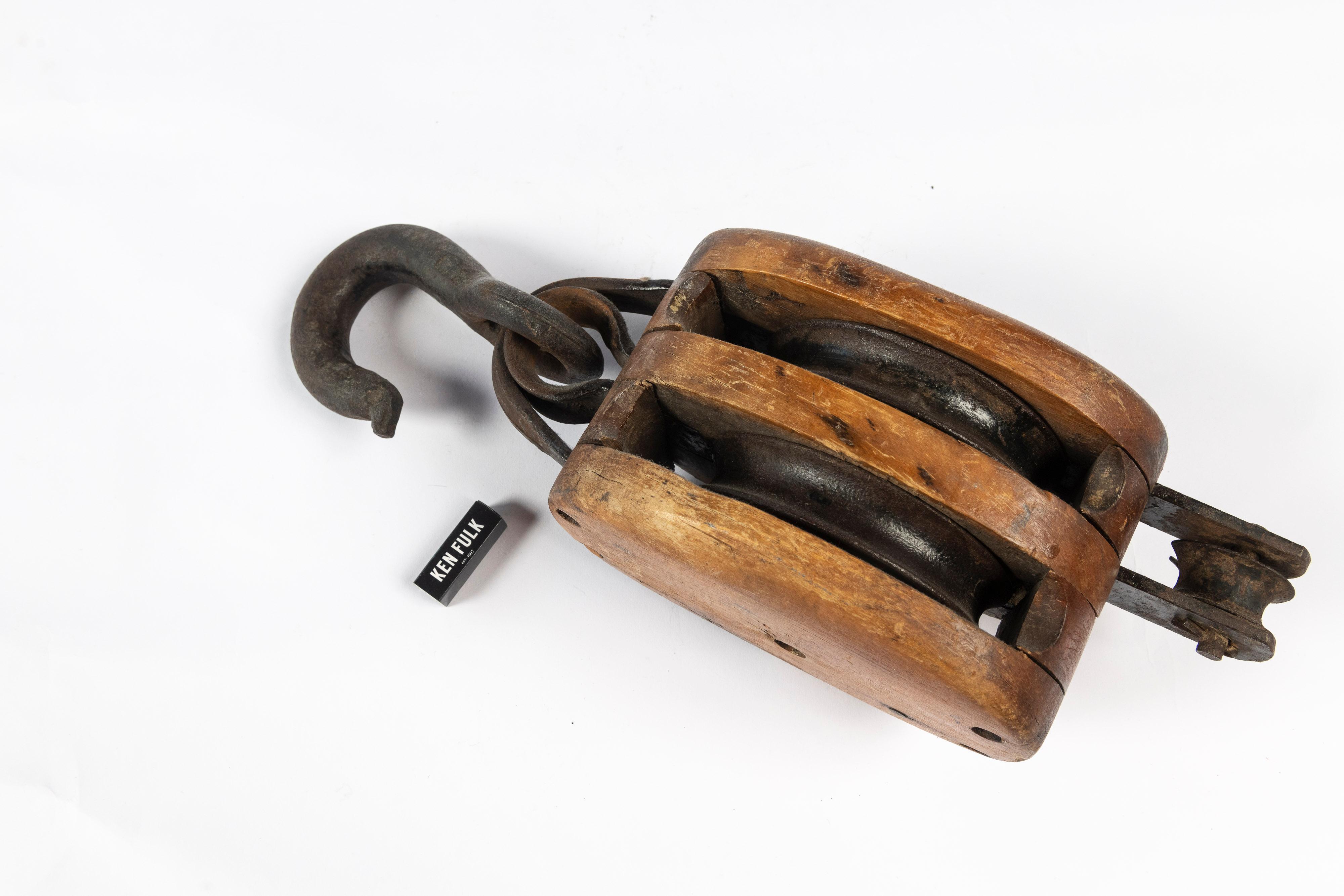 Beautiful vintage wood and iron pulley in excellent working condition. May have been used to hoist the sails of a ship or to lift bales of hay in an antique barn. Today, this functional pulley, with its aged patina, is perfect for industrial, farm