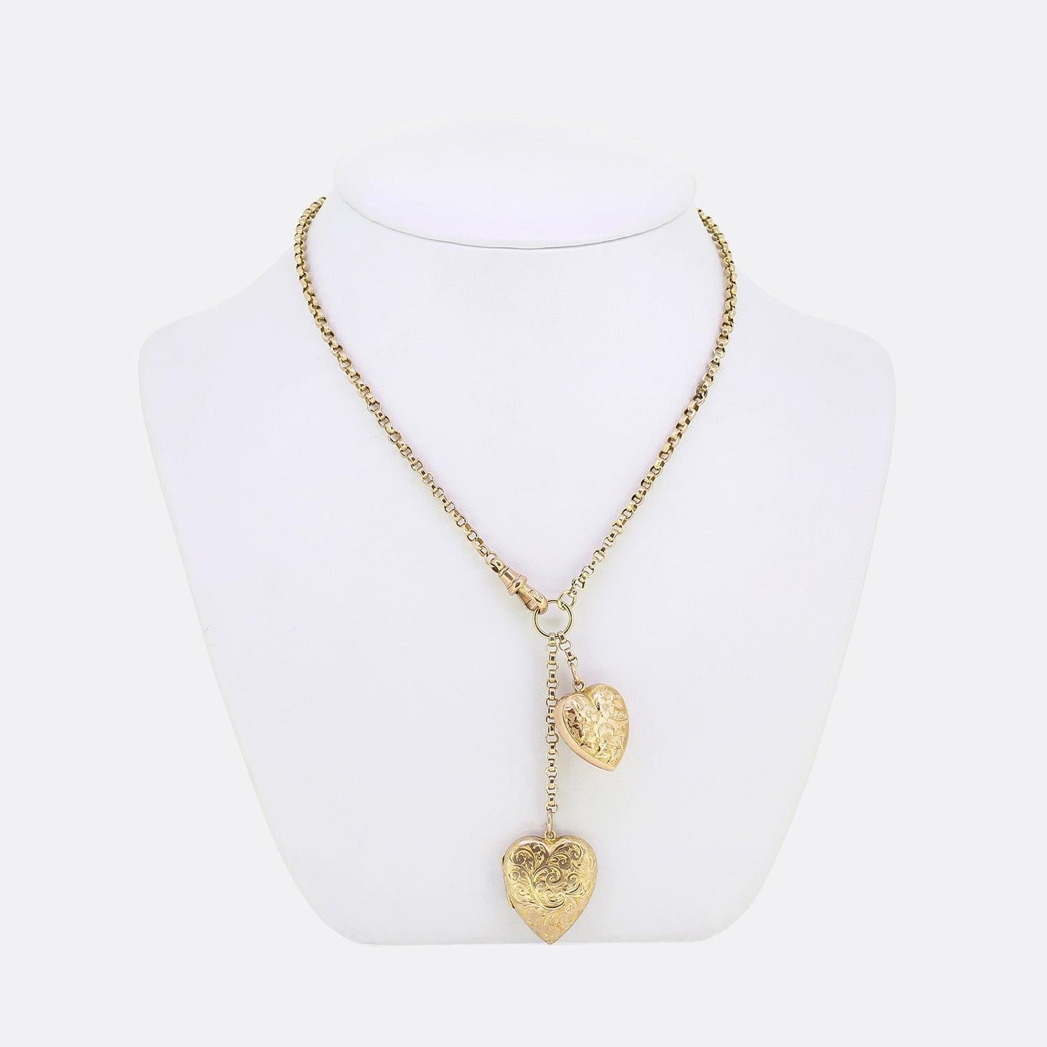 This is a vintage 9ct yellow gold belcher chain charm necklace. The necklace features two love heart pendants; both of which feature intricate floral engraving and the larger heart is a double sided locket. The necklace is securely attached by an