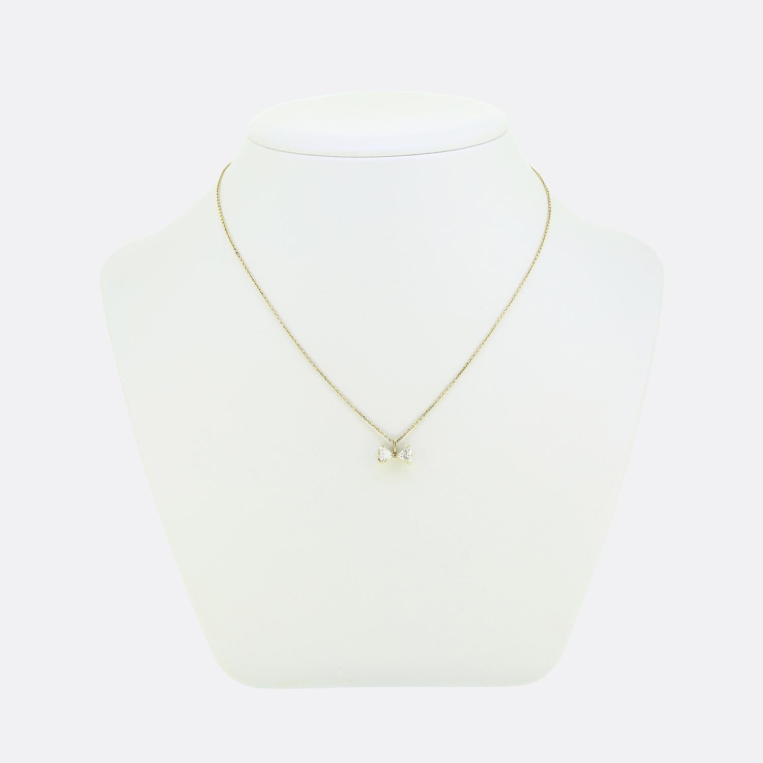 Hier haben wir eine charmante Halskette aus luxuriösem 18-karätigem Gelbgold. Dieses Vintage-Stück ist ein einzigartiger Anhänger, der aus zwei strahlend weißen Diamanten im Herzschliff besteht, die elegant in Form einer Schleife gefasst sind. Die