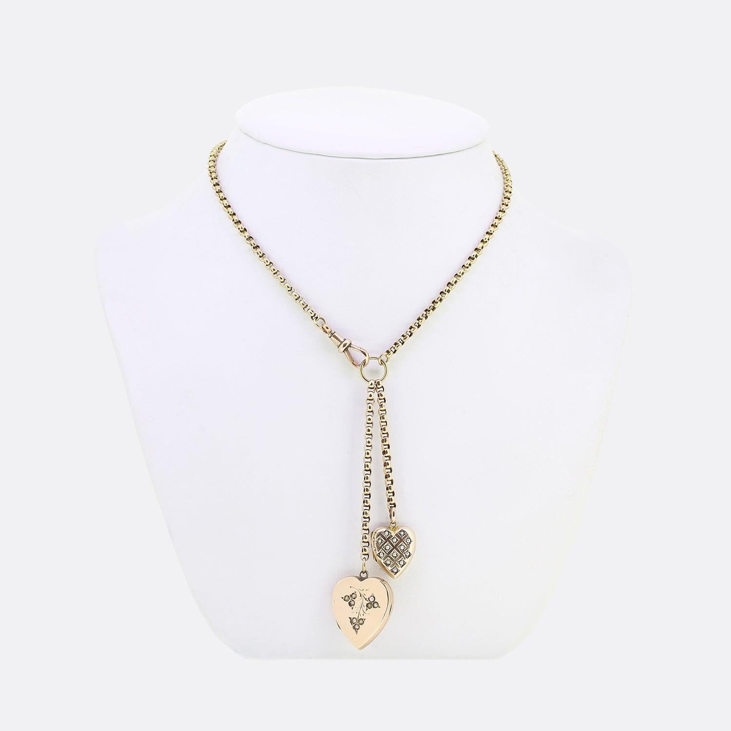 Here we have a vintage 9ct yellow gold belcher chain link charm necklace. The necklace plays host to a duo of love heart lockets which hang harmoniously side-by-side; each of which is set with an array of seed pearls and can be opened allowing the