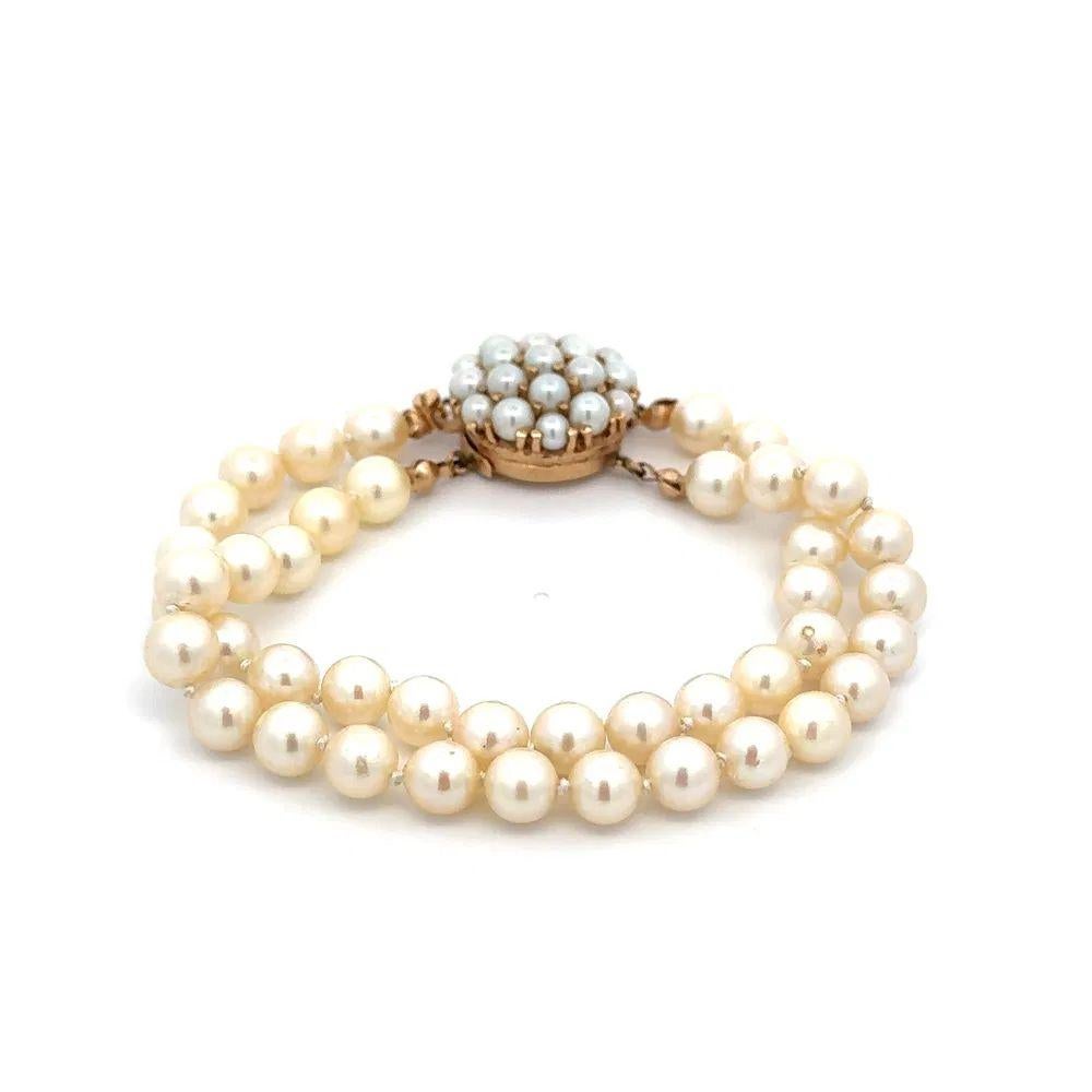 Tout simplement magnifique ! Bracelet vintage à deux brins de perles de 6,5 mm. Le fermoir est composé d'une grappe de perles et est réalisé à la main en or jaune 18 carats. Le bracelet mesure environ 7.25