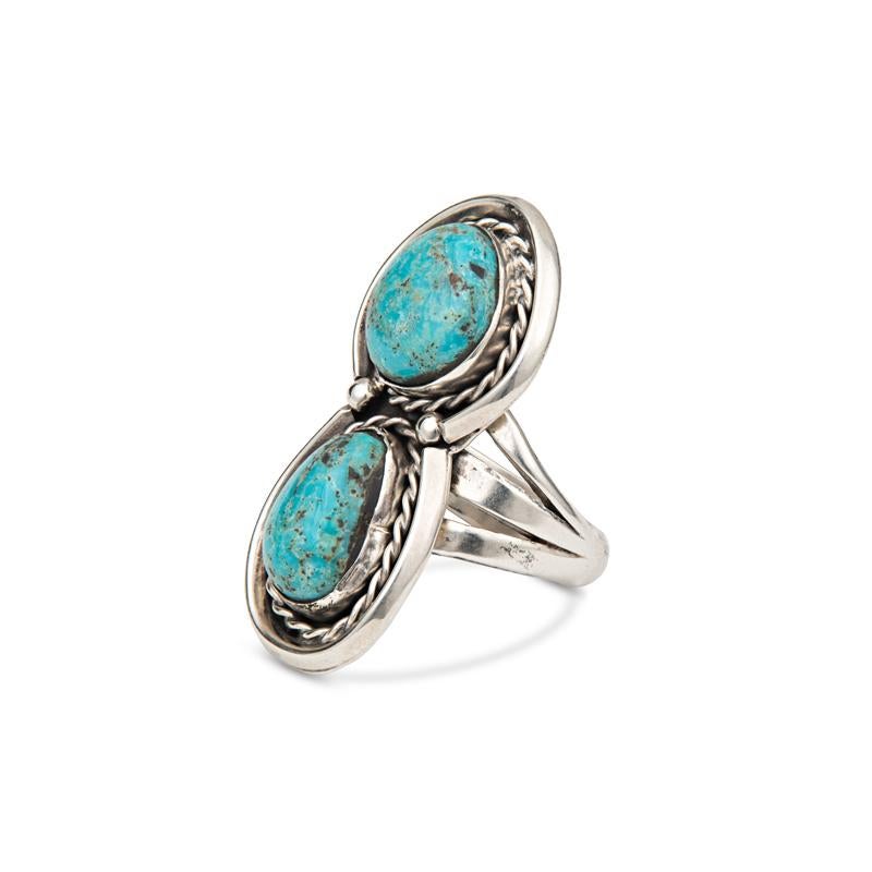 This vintage sterling silver ring features two natural turquoise stones stacked on top of each other and surrounded by braiding details and set on a triple shank. It is a great statement ring! It is a size 8 but can be resized for a nominal fee. The