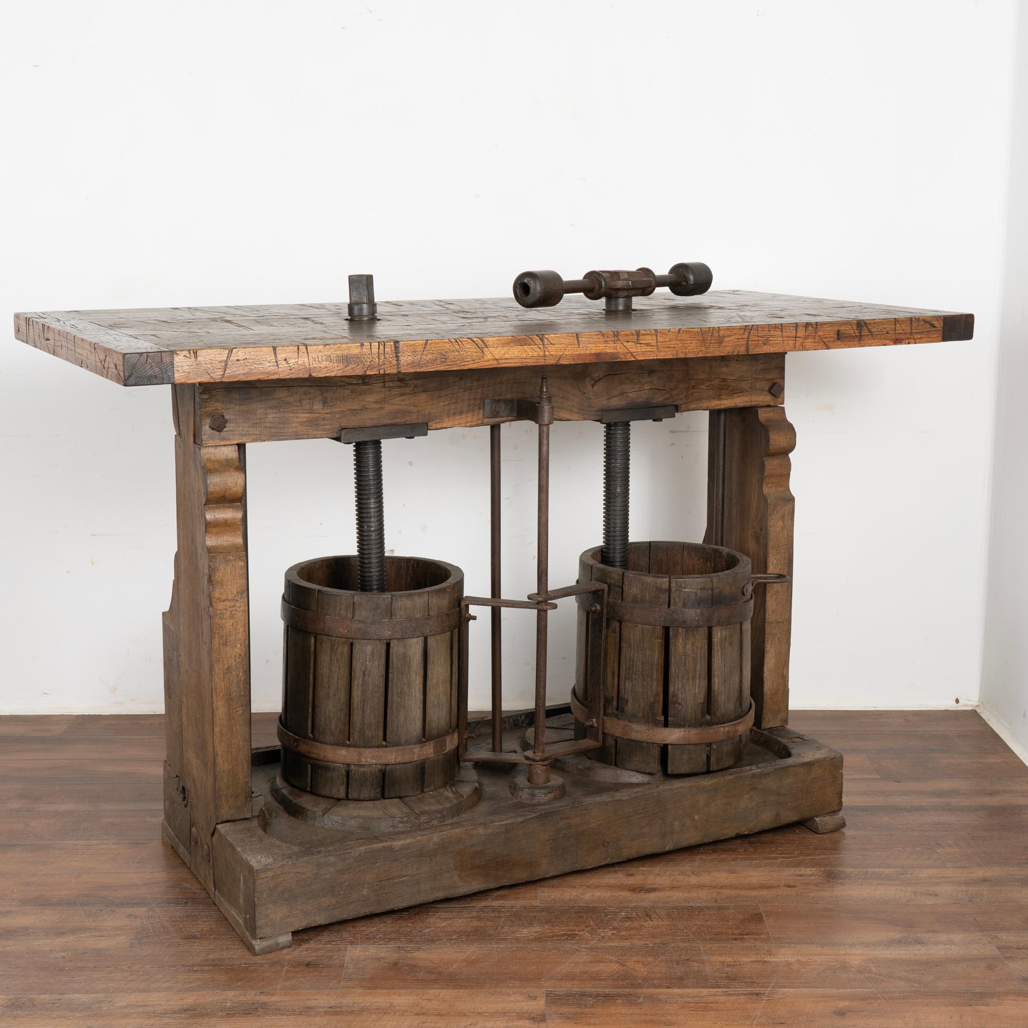 This all original wine tasting or bar top table was creating with an antique double wine press from Hungary serving as the unique and impressive base.
The top is made from old boxcar/railroad cart flooring which adds a strong balance to the
