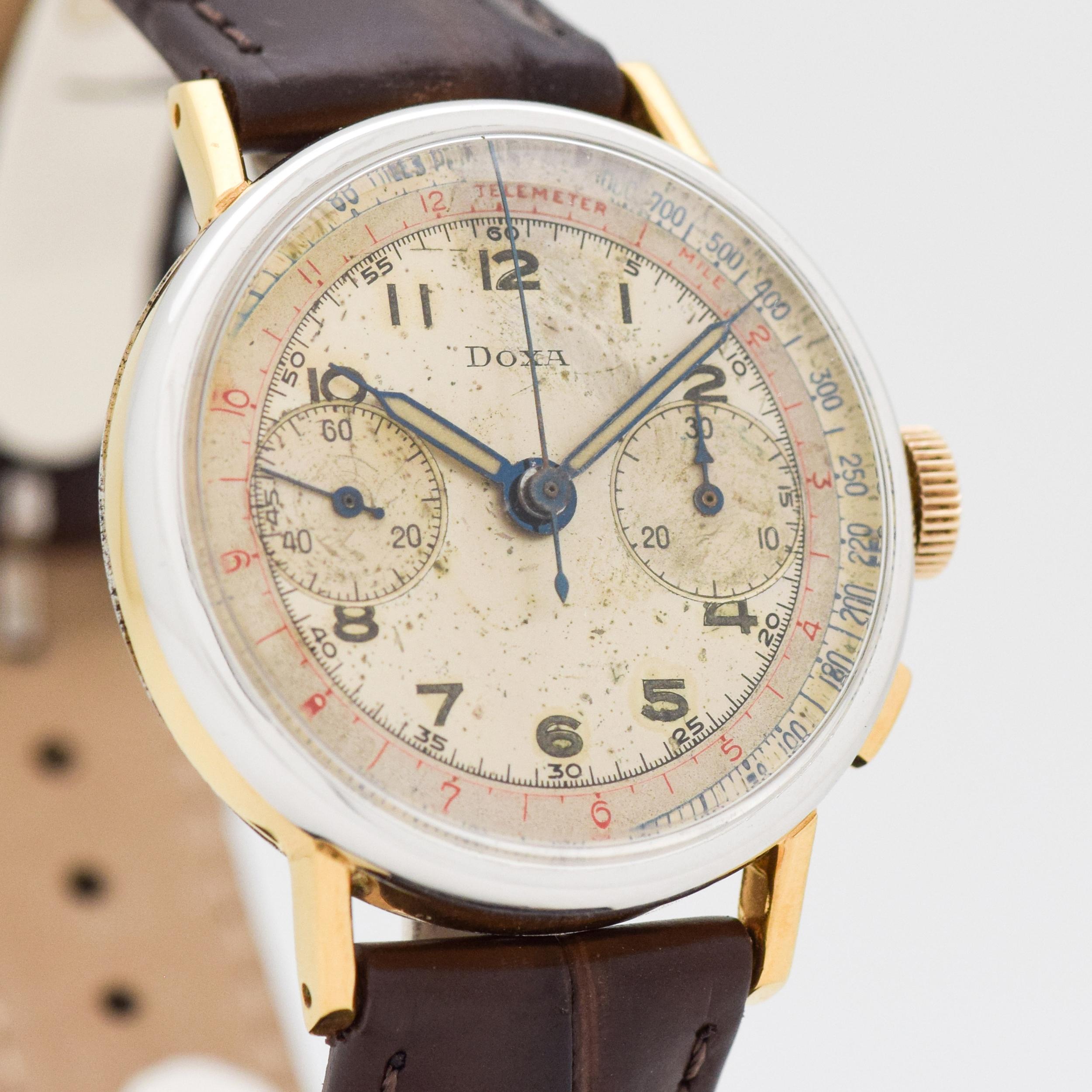1950's Vintage Doxa 2 Register Chronograph Two Tone 14k White Gold Filled Bezel with 14k Yellow Gold Filled Case and Stainless Steel Case Back with Original Silver Dial with Luminous Arabic Numbers with Red and Blue Outer Tachometer Tracks. 34mm x
