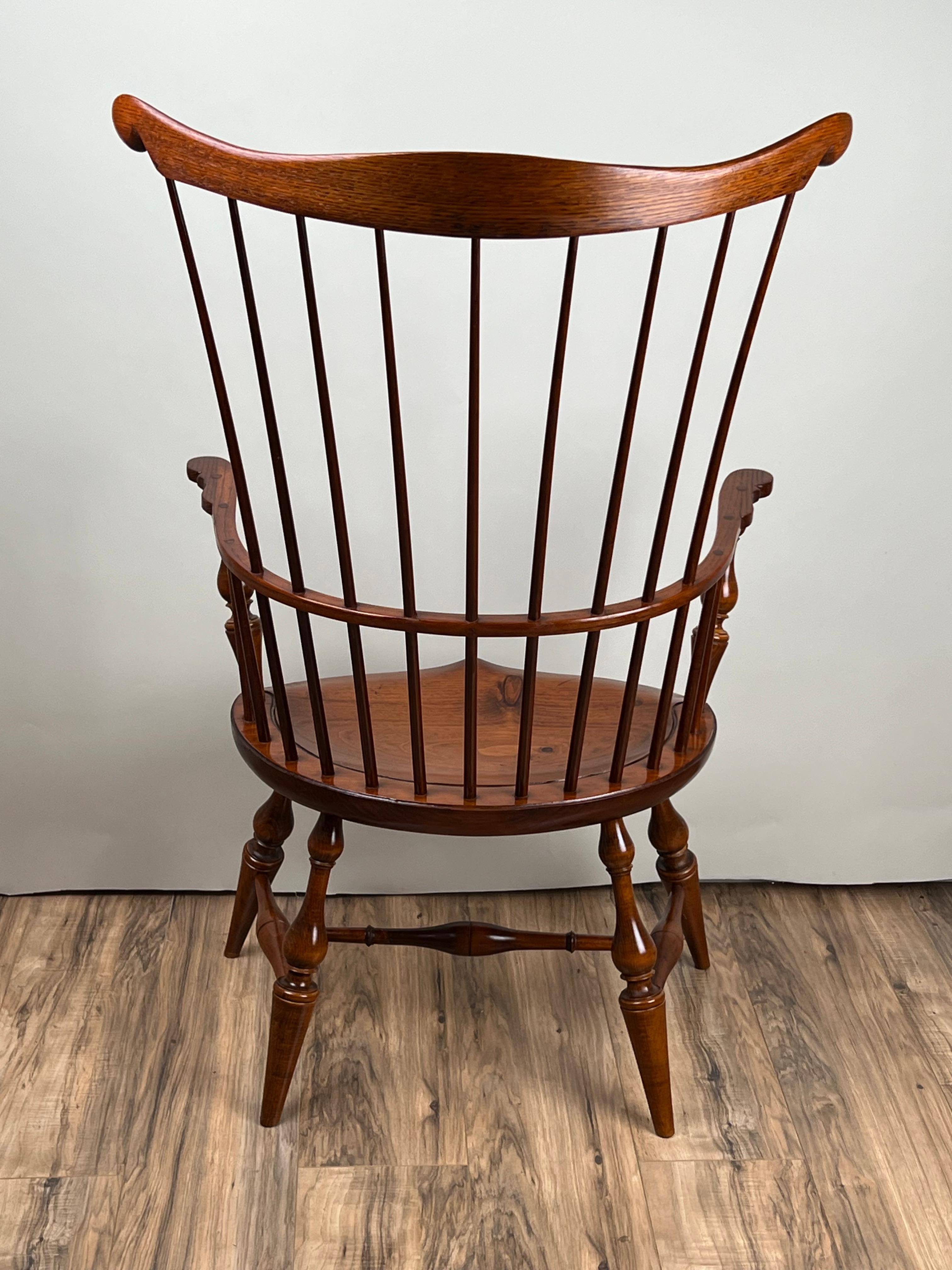 Ce fauteuil Windsor vintage à dossier peigne de D.R. Dimes est un superbe exemple de l'artisanat américain dans la tradition du XVIIIe siècle. Fabriqué à partir de bois indigènes mélangés - l'assise en pin massif, les pieds et les traverses en