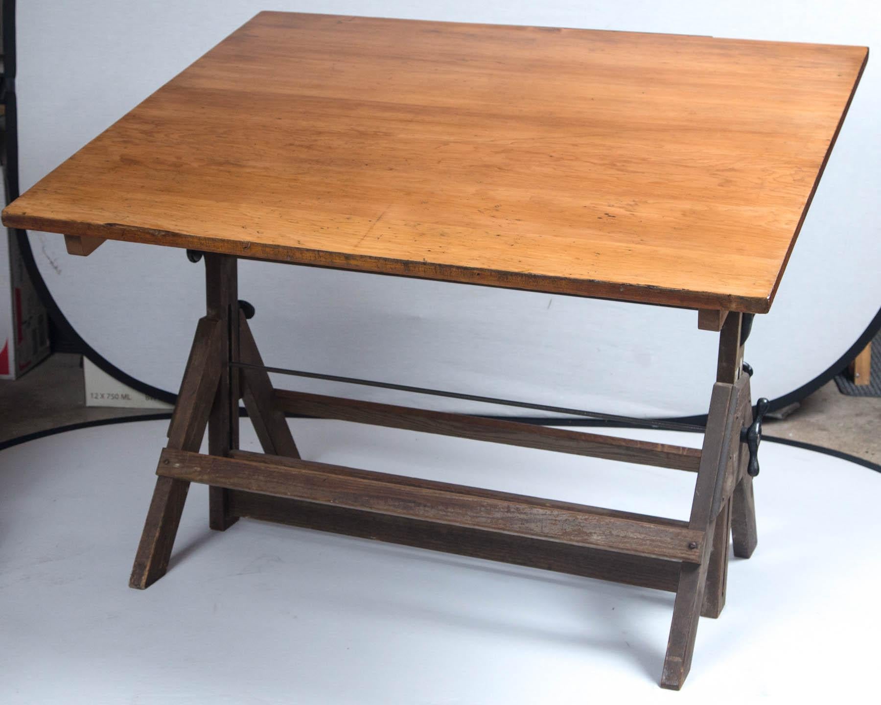 Vintage drafting table by Hamilton, circa 1940. Oak base with pine work surface, cast iron hardware. Tabletop height can be raised and positioned at varying angles. 
 