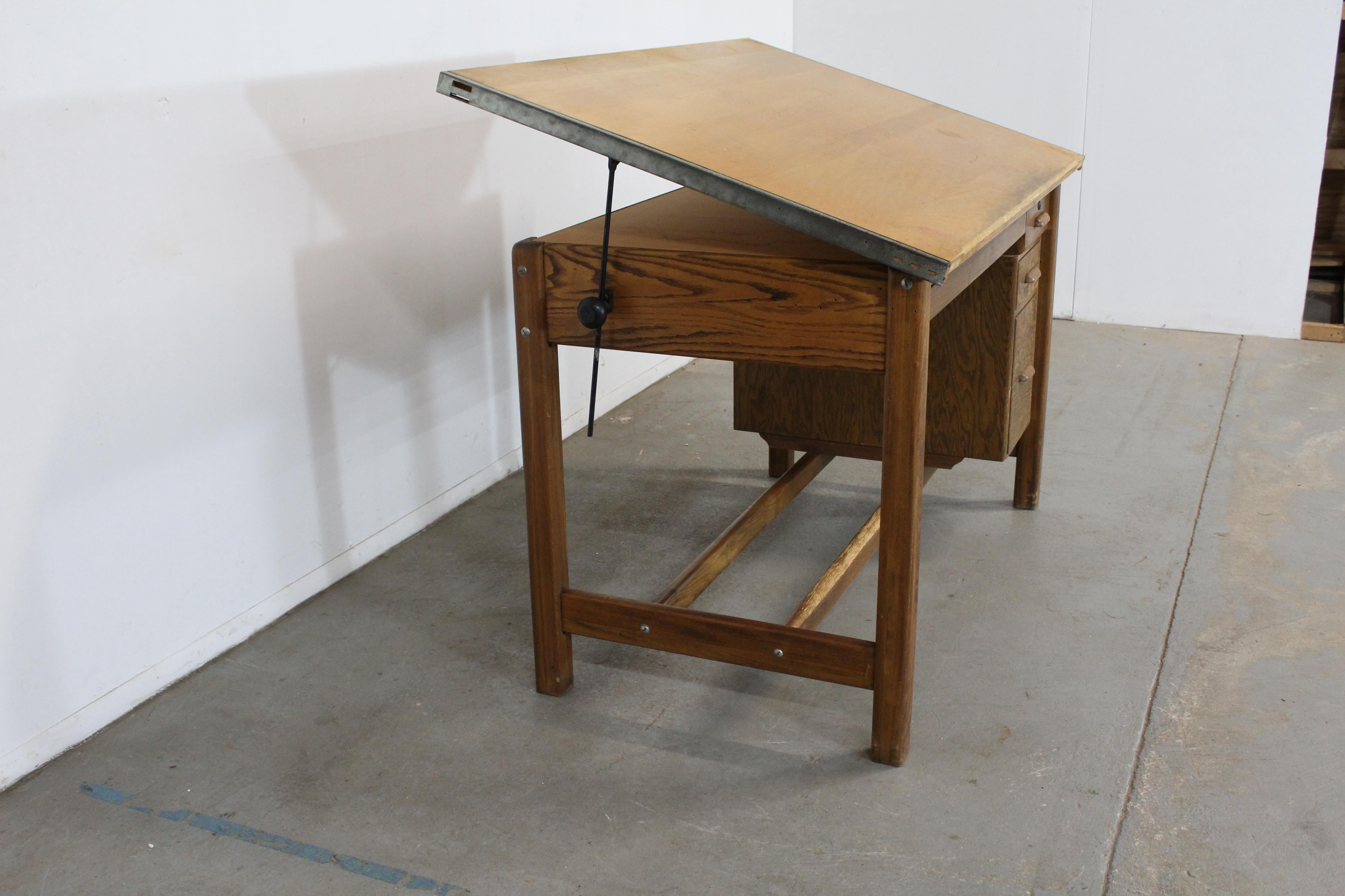 Vintage Industrial Adjustable Wood Drafting Table Desk

Offered is a vintage, adjustable drafting table from the 1960's, made of wood (Oak) with iron hardware. The table top and height are adjustable (please message us for more measurements). The