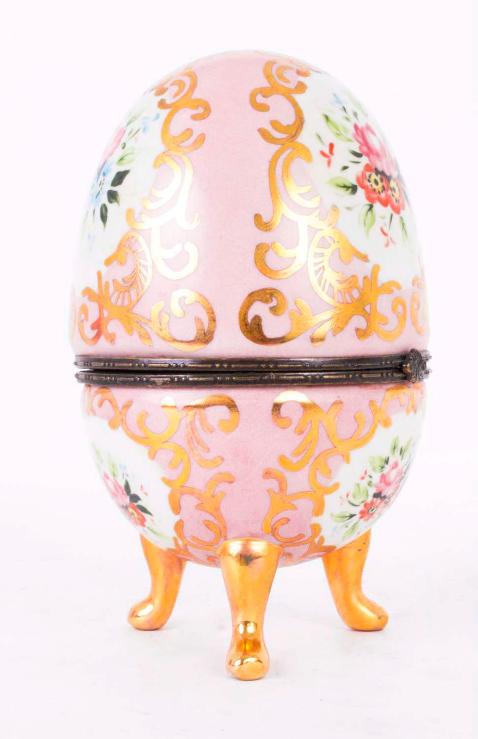 This is a stunning hand painted rose pink porcelain egg with hand painted floral decoration, applied gilding and ormolu mounts in the manner of Dresden, dating from the last quarter of the 20th century.

The egg stands on three gilded legs and