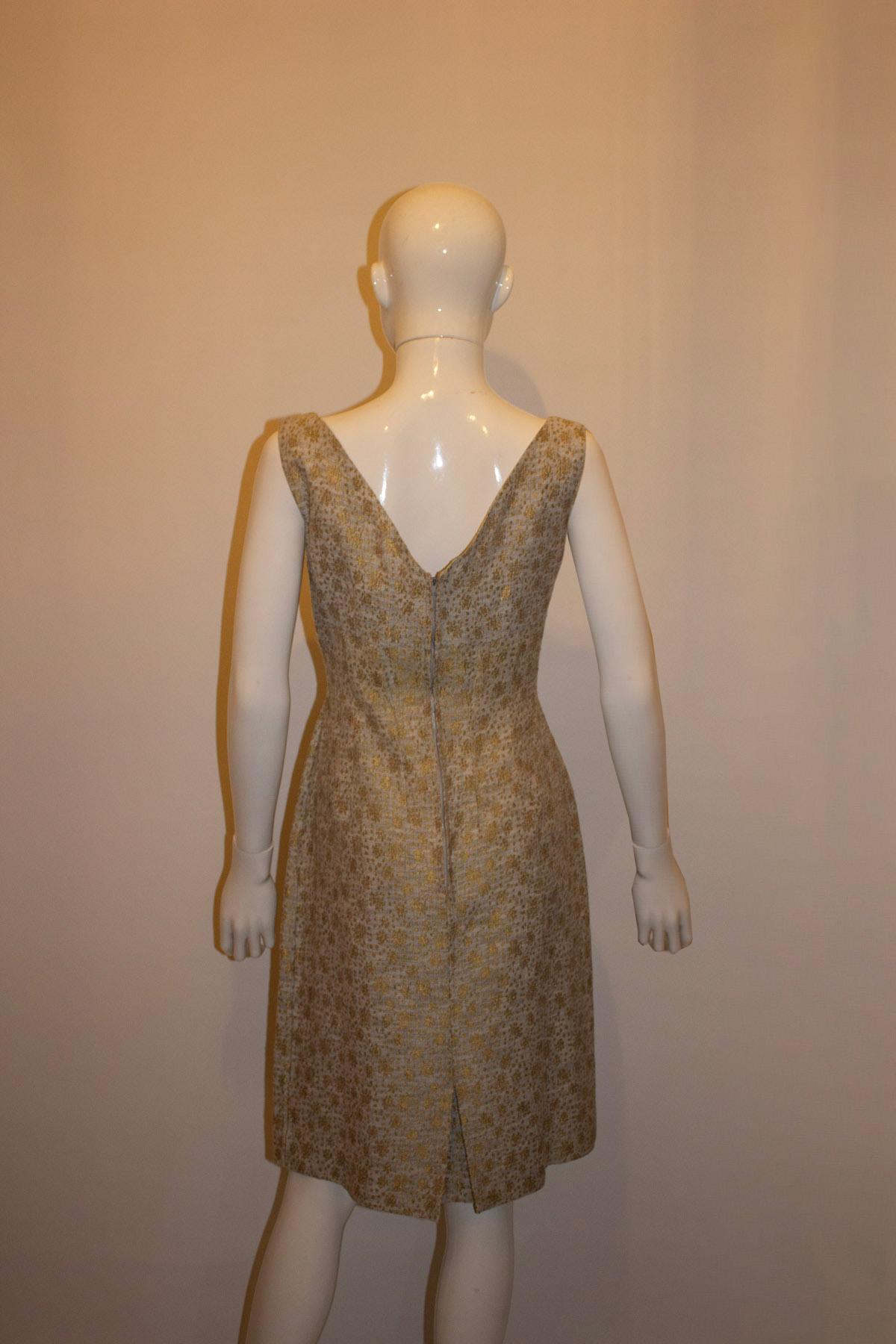 A wonderful vintage outfit for a wedding , bahmitza or other special event.  In a pretty blue and gold fabric , the dress has a fabric flower over the bust and a v back line. The coat has a stand up collar and pocket on either side. with elbow