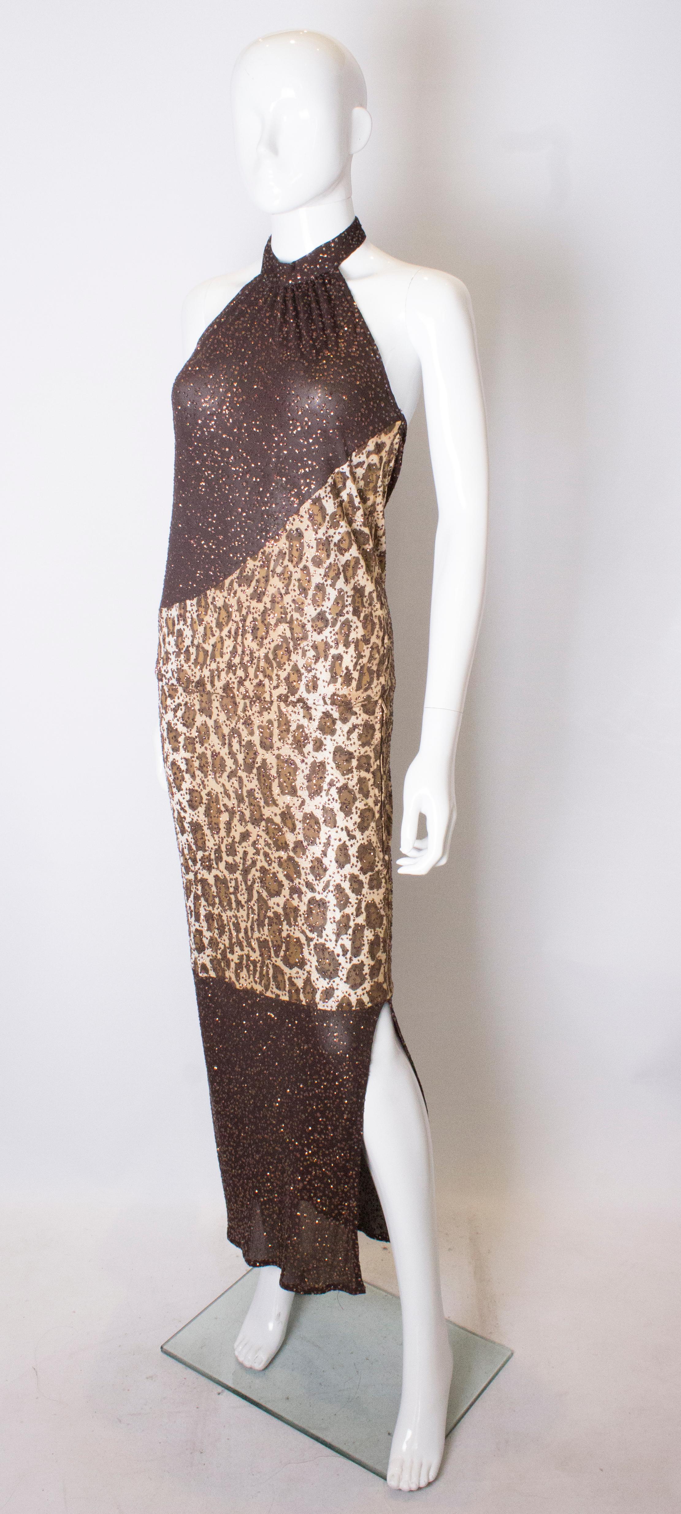 A great dress for Summer, by Angelo Tarlazzi, Paris. The dress is in an animal print with metallic embellishment. It has a halter neck, side zip opening and 18'' slit on one side.