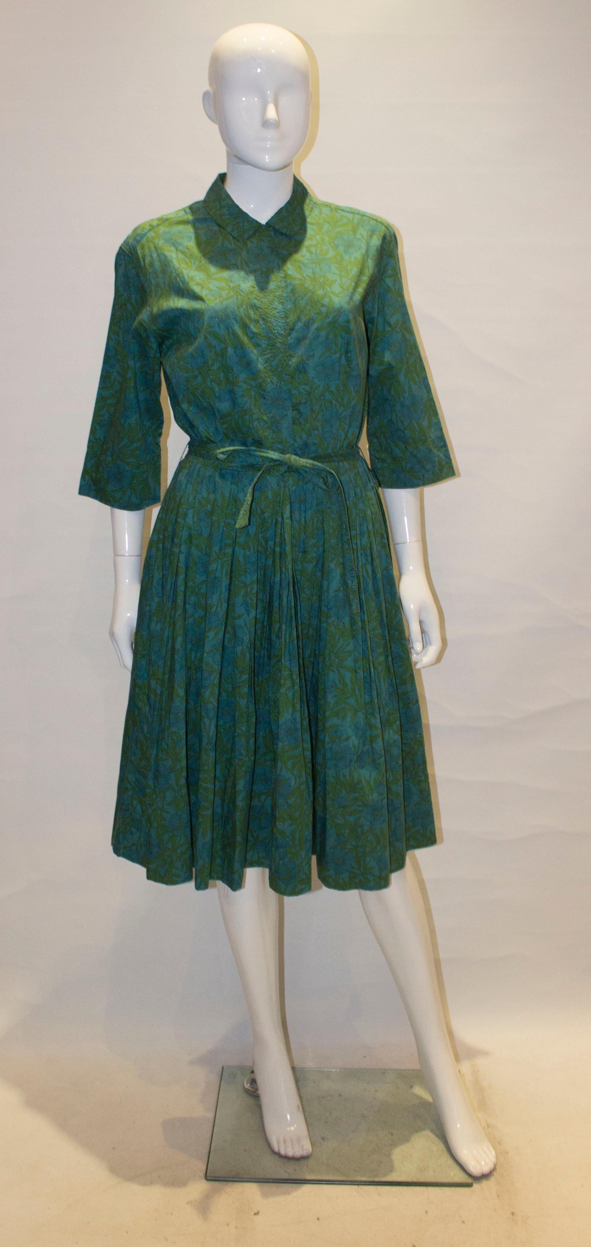 A lovely vintage dress by Best an Co, 5th Avenue.  The dress is in a green and blue floral print  with stitch detail on the collar. It has a three button front opening , with a hook and eye fastening at the waist. The dress has elbow length sleeves,