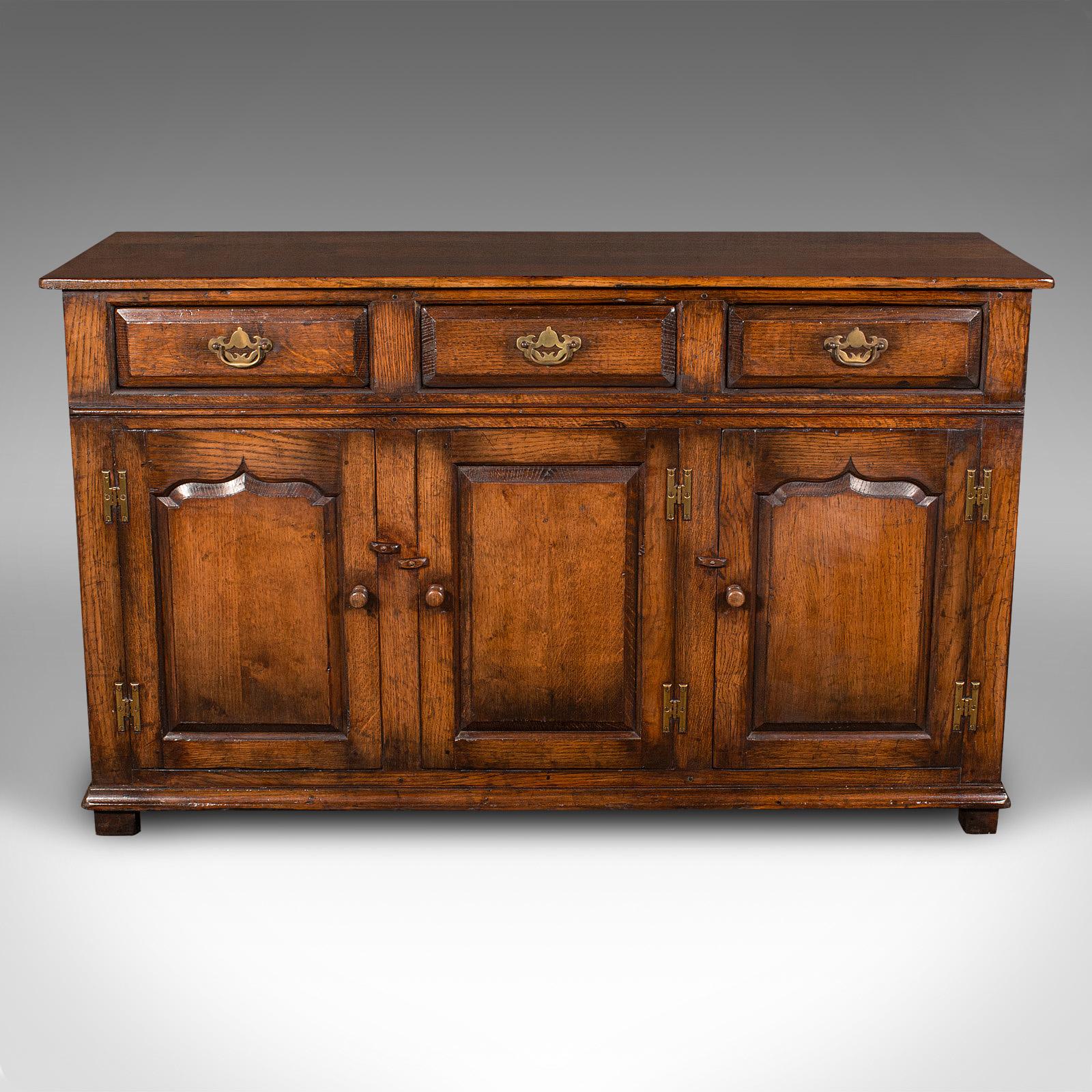 This is a vintage dresser base. An English, oak side cabinet in Georgian revival taste, dating to the late 20th century, circa 1970.

Traditional appeal with a fine Georgian revival taste
Displaying a desirable aged patina and in good order
Fine oak